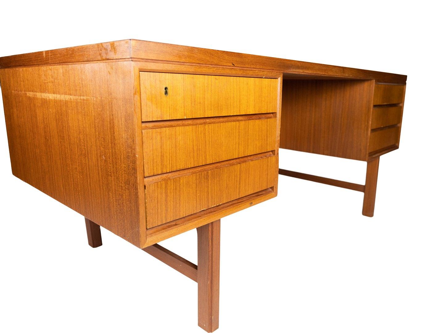 Le bureau en teck, conçu par Design/One Junior dans les années 1960, est un exemple marquant du mobilier danois de l'époque.

Avec son design caractéristique en bois de teck, le bureau dégage une atmosphère chaleureuse et accueillante qui s'intègre
