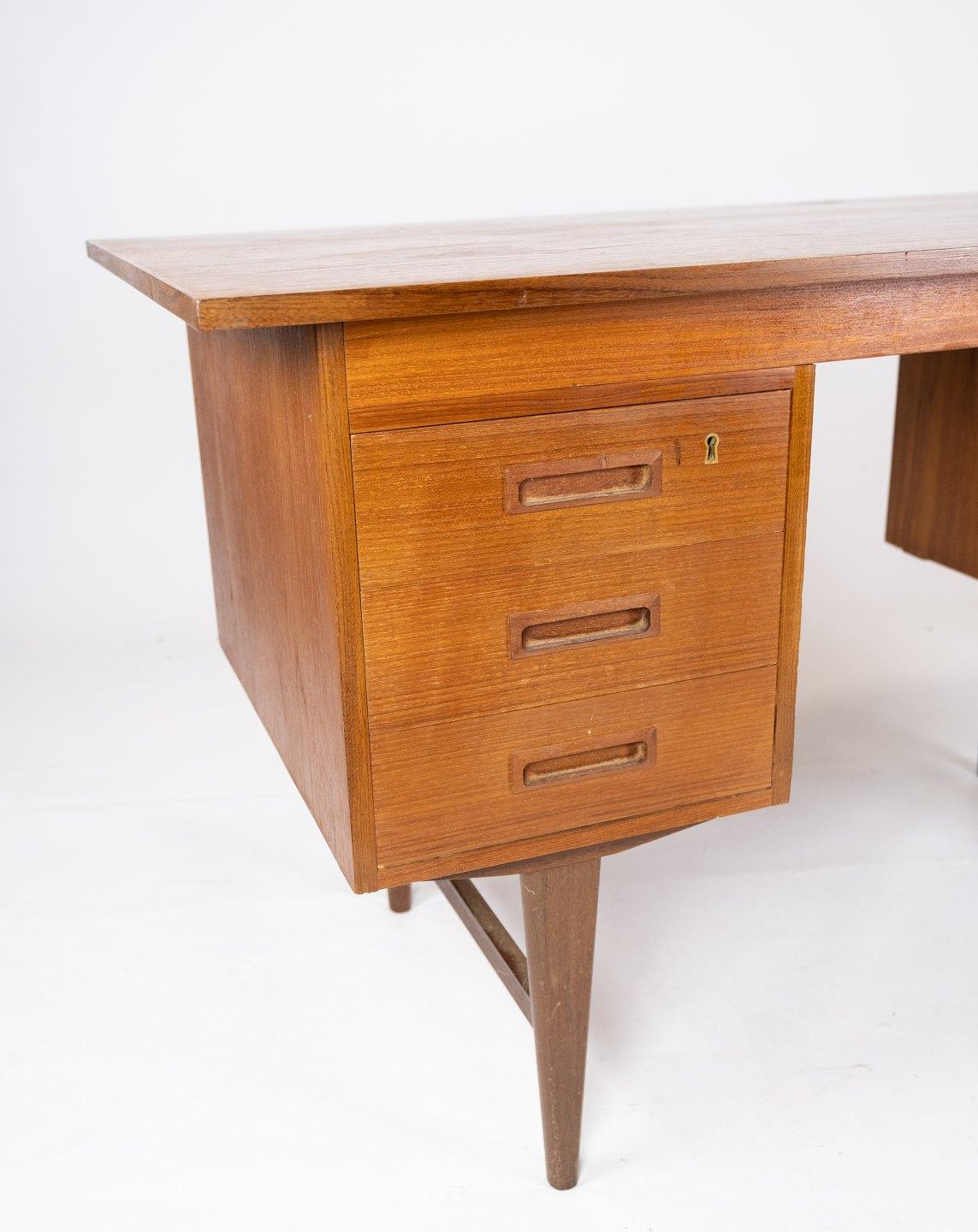 This desk is an example of Danish design from the 1960s and is made of teak wood, which gives it a natural and timeless look. The beautiful golden color and unique wood grain add character and warmth to any room. With its simple, yet elegant design,