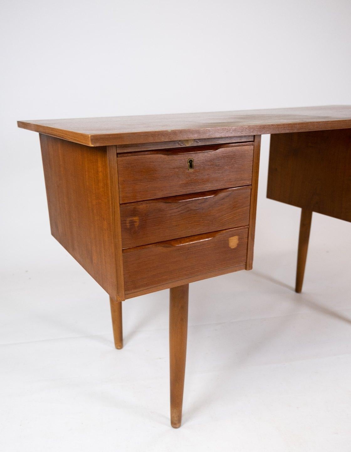 This desk is a beautiful example of Danish design from the 1960s, made of teak wood, which gives it a natural and timeless look. The beautiful golden color and unique wood pattern add character and warmth to any room. With its simple and elegant