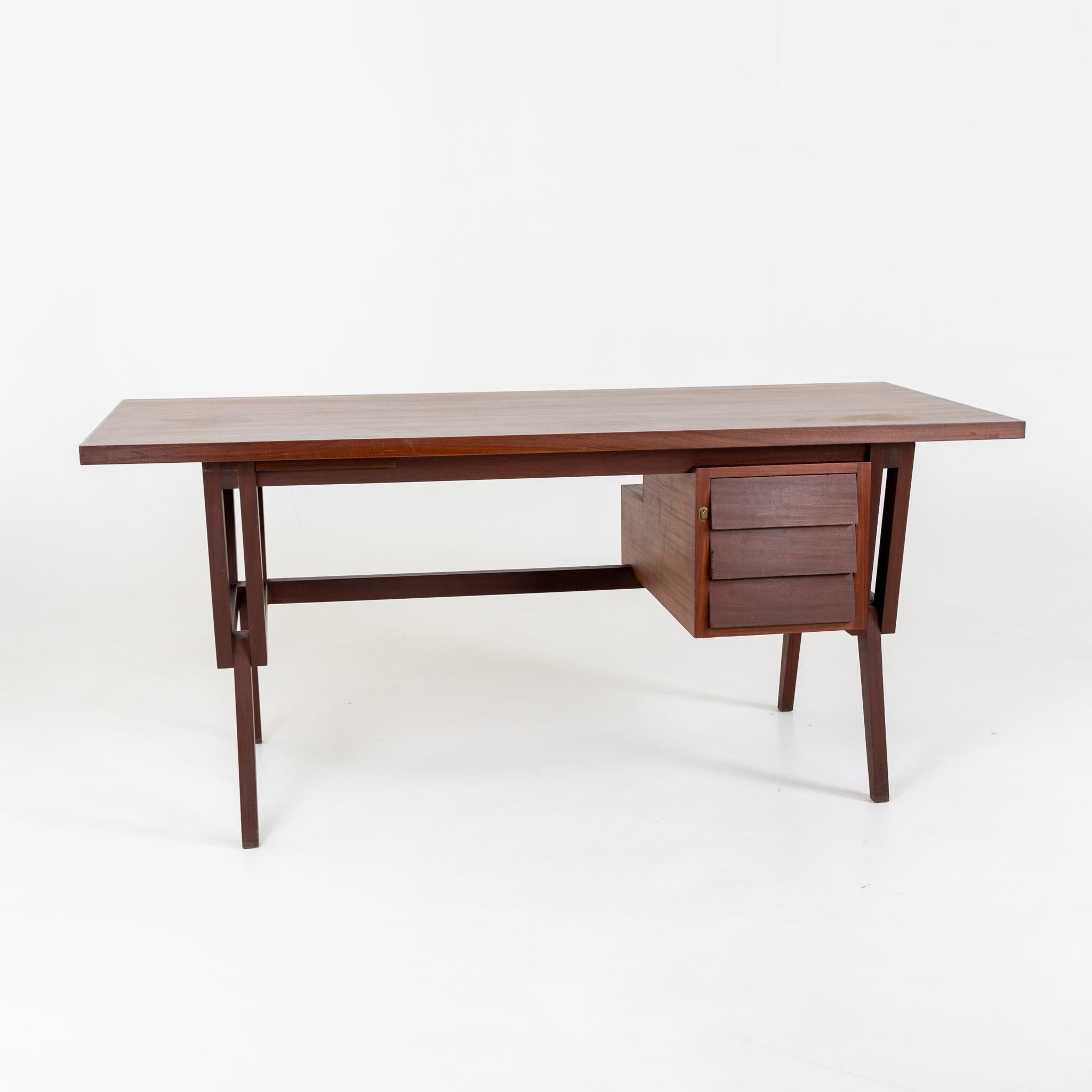 Italian desk in the style of Ico Parisi with unusually designed base and side drawer element. The back offers a storage compartment. Unrestored original condition.