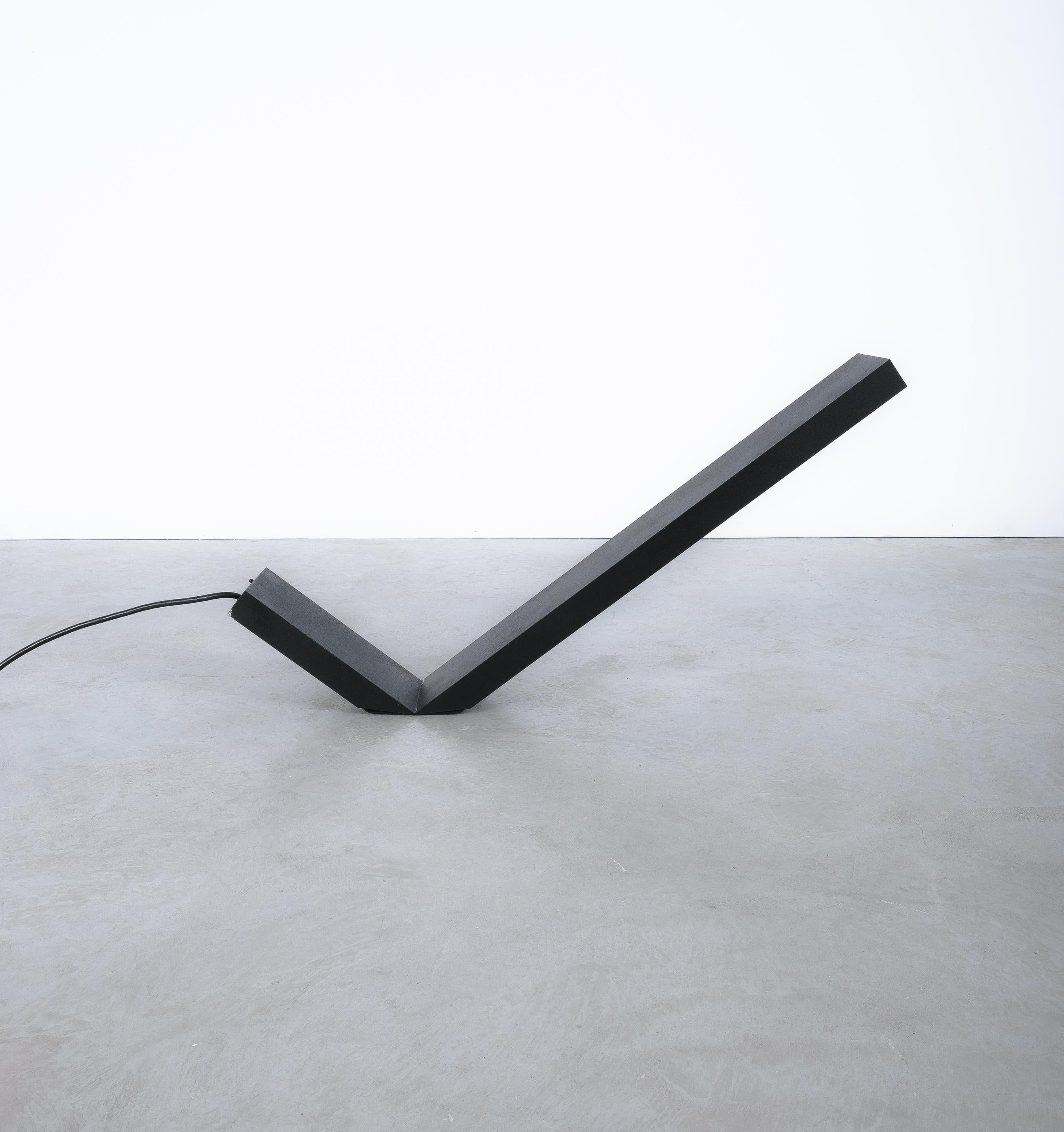 Black table lamp in form of a check sign, Italy, circa 1970

Neat minimal design desk lamp from Italy comprised of lacquered aluminum. It holds one halogen bulb and can be switched into 2 different intensity levels. 
Dimensions are 23.62