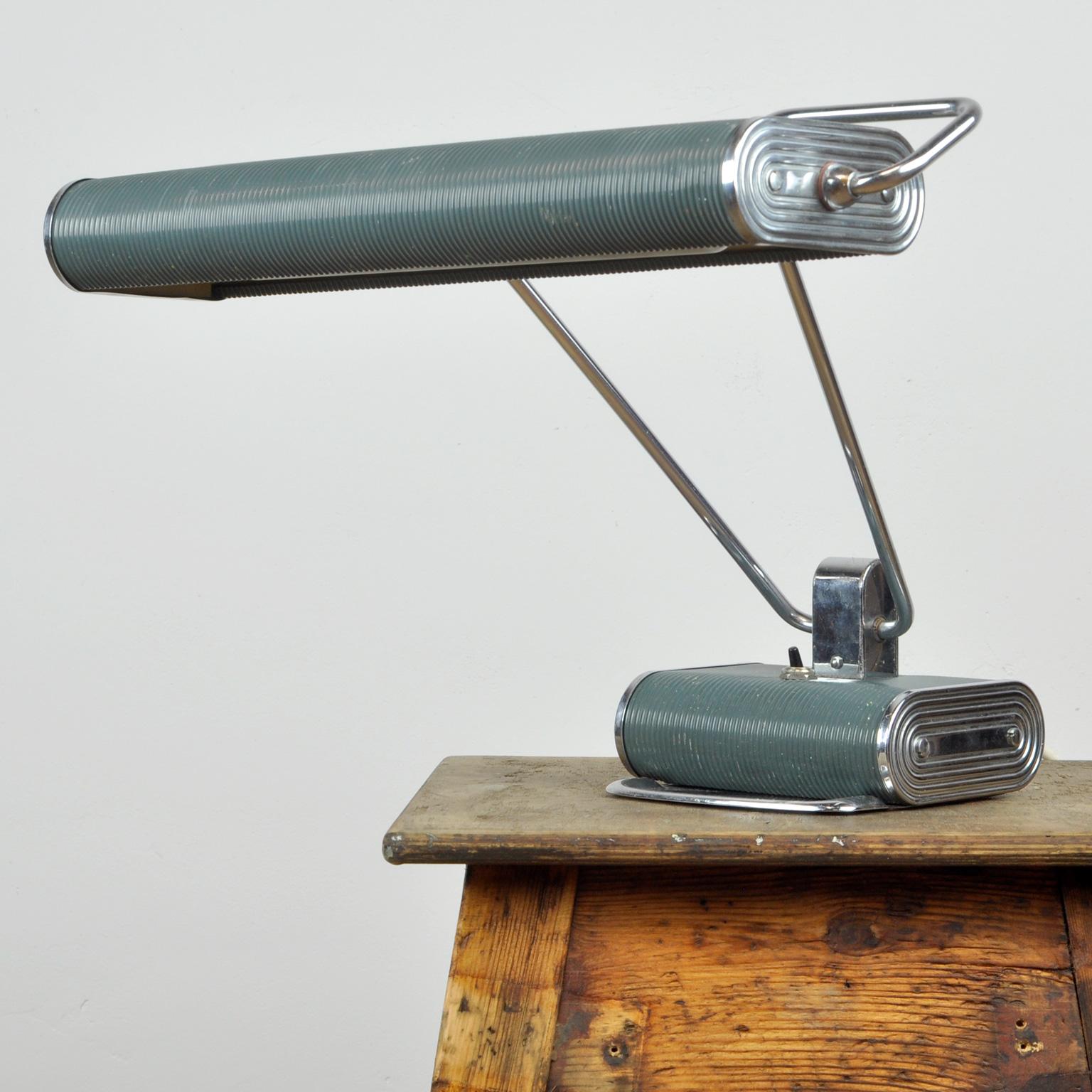 This lamp was designed by Eileen Gray for Jumo in France circa 1950. The lamp consists of corrugated steel and the original grey-painted and chromed brass pipe. The long double arm can be tilted forward as well as backward and the wide reflector
