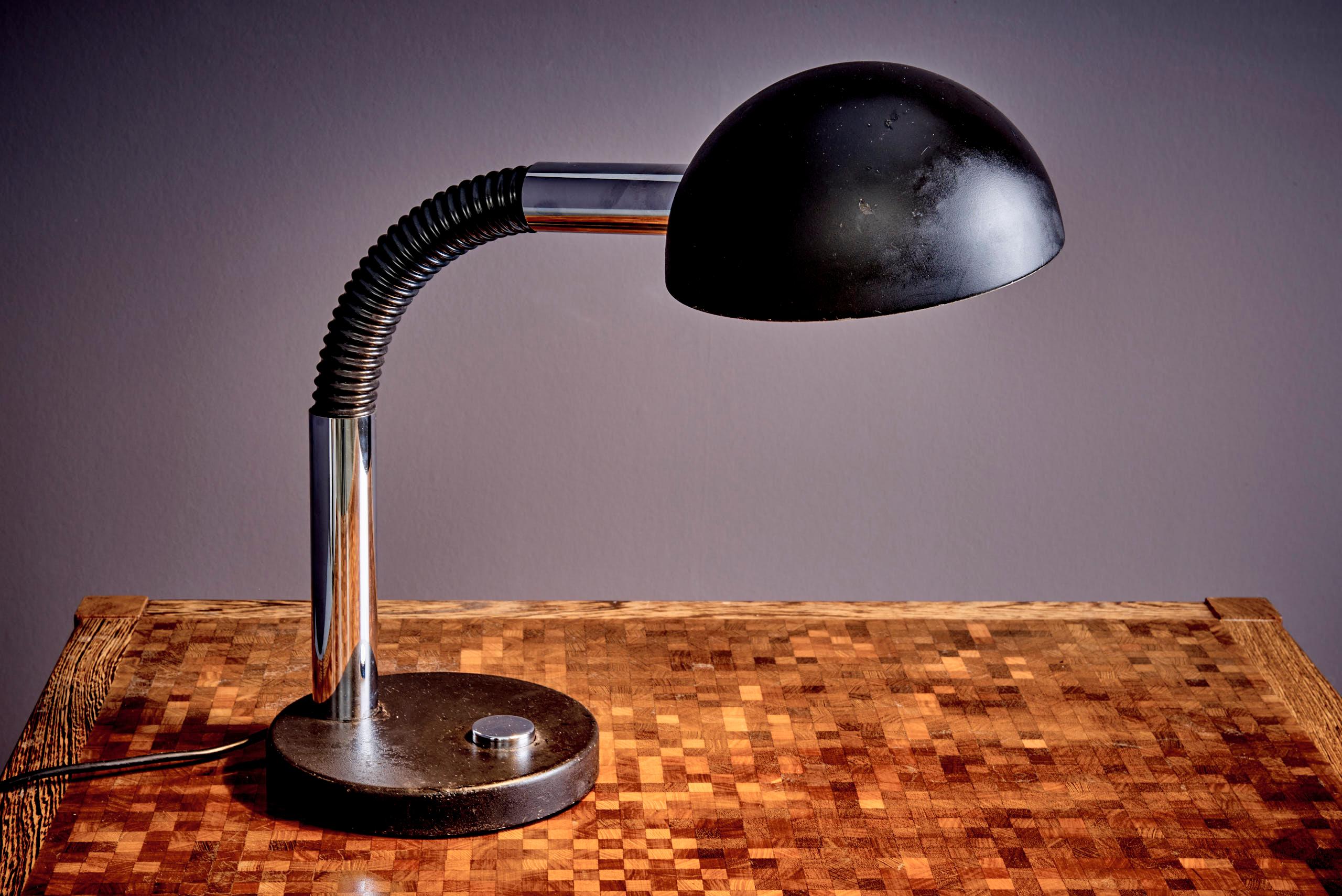 Diese Vintage-Schreibtischlampe, die in den 1970er Jahren von dem bekannten Unternehmen Hillebrand Lighting entworfen wurde, verfügt über einen schwarzen Sockel mit einem silbernen Knopf zum Ein- und Ausschalten der Lampe.  und einem passenden
