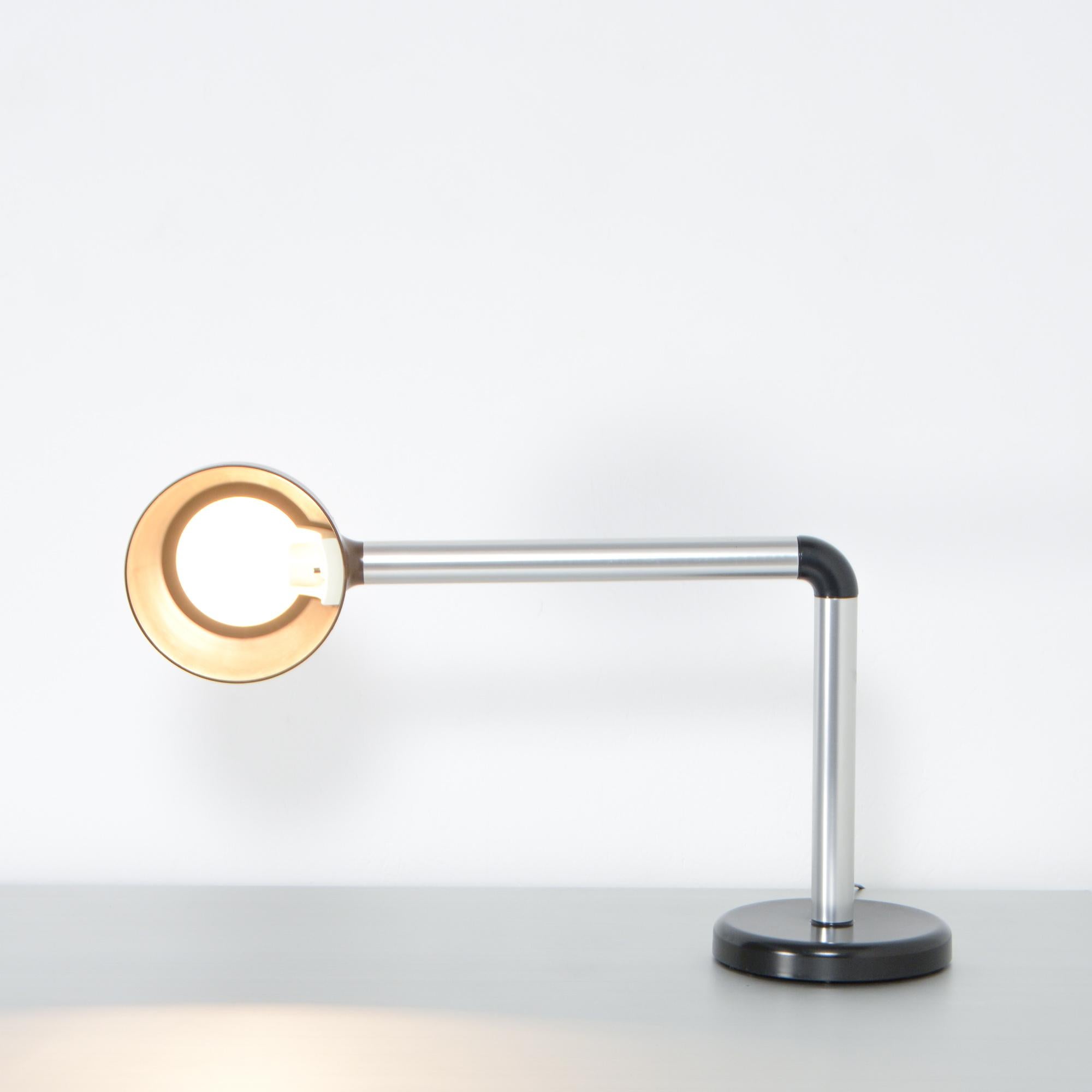 This desk lamp was designed by Robert Haussmann for Swiss Lamps International in 1965.
This great lamp is made of brushed aluminium tubes, fixed with a black plastic node. The shade is also made of black plastic.
The black heavy foot keeps the