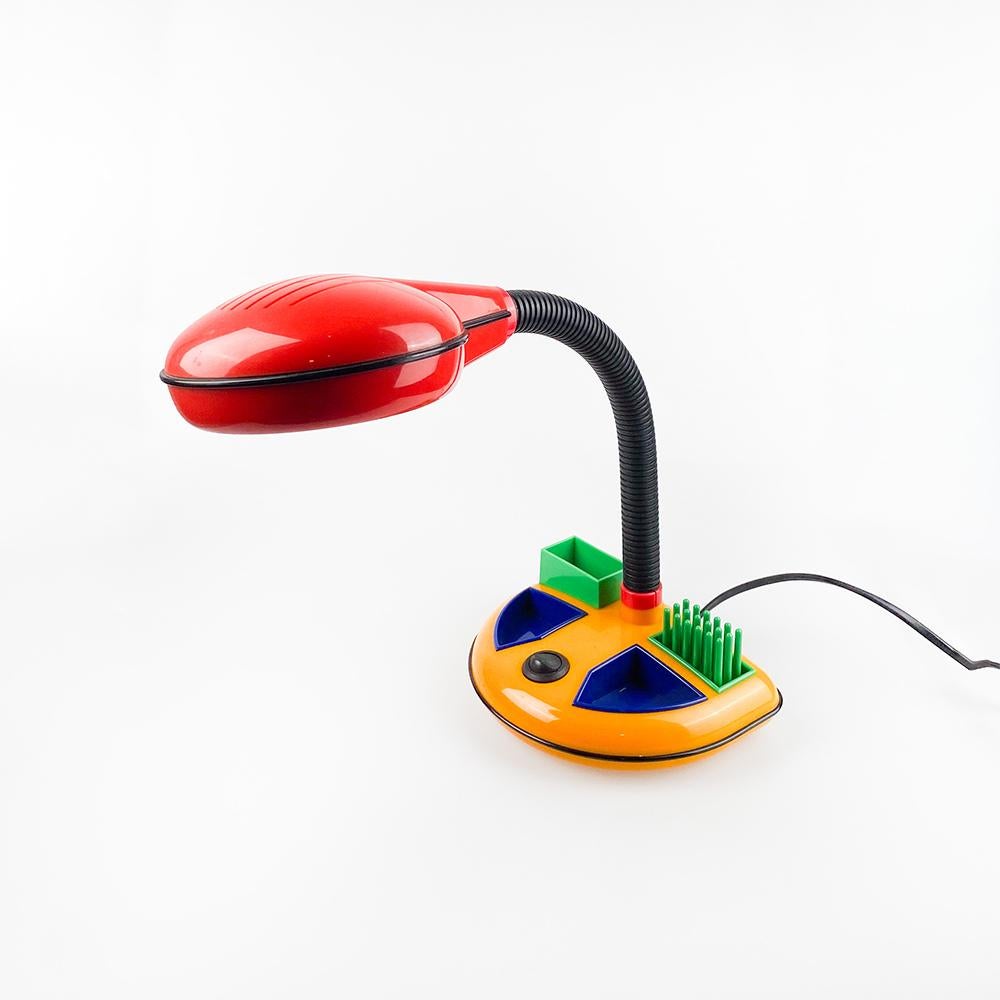 Desk lamp designed by Kyoji Tanaka for Rabbit Tanaka Corp, Ltd. 1980's

Plastic in primary colors. Base with desk organizer.

Bulb E14 Max. 40w. European cable.

Measurements: 35x28x19
