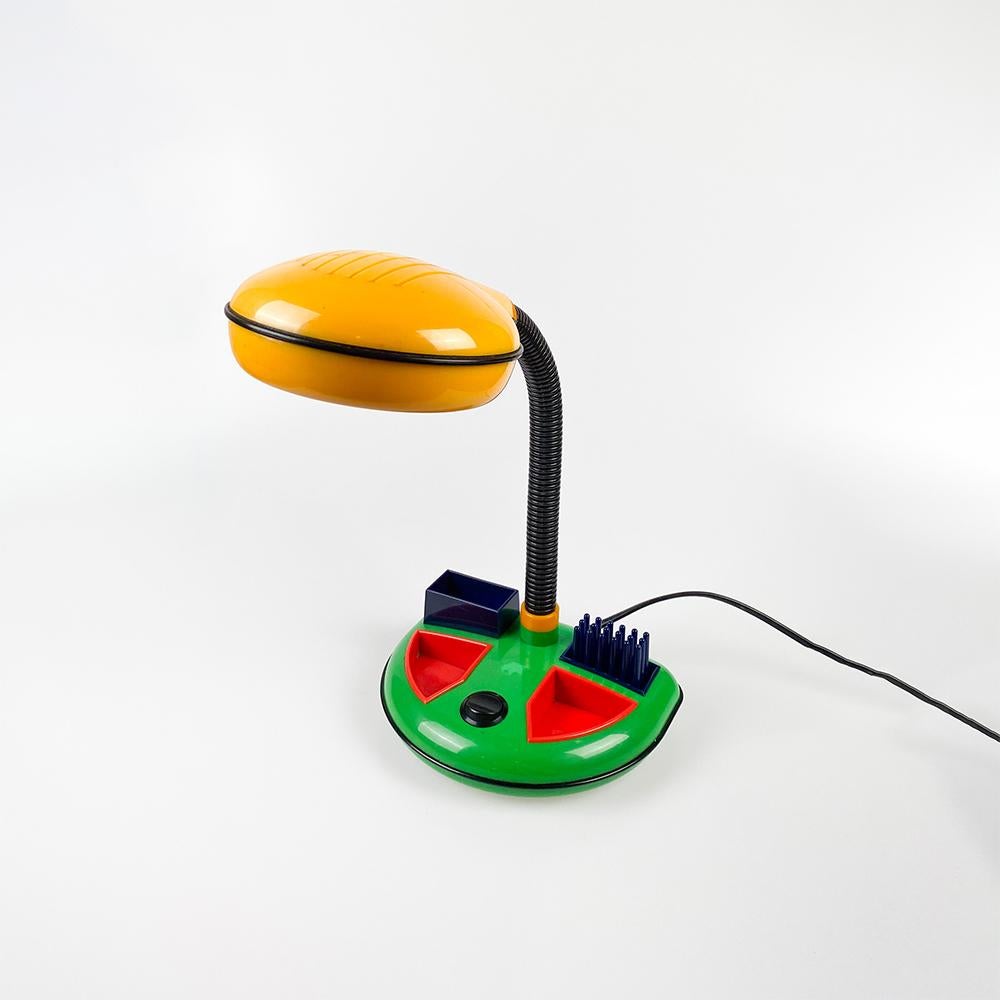 Lampe de bureau conçue par Kyoji Tanaka pour Rabbit Tanaka Corp, Ltd. 1980s

Plastique en couleurs primaires. Base avec organisateur de bureau.

Petite décoloration à la base.

Ampoule E14 Max. 40w. fil européen.

Dimensions : 35x28x19.