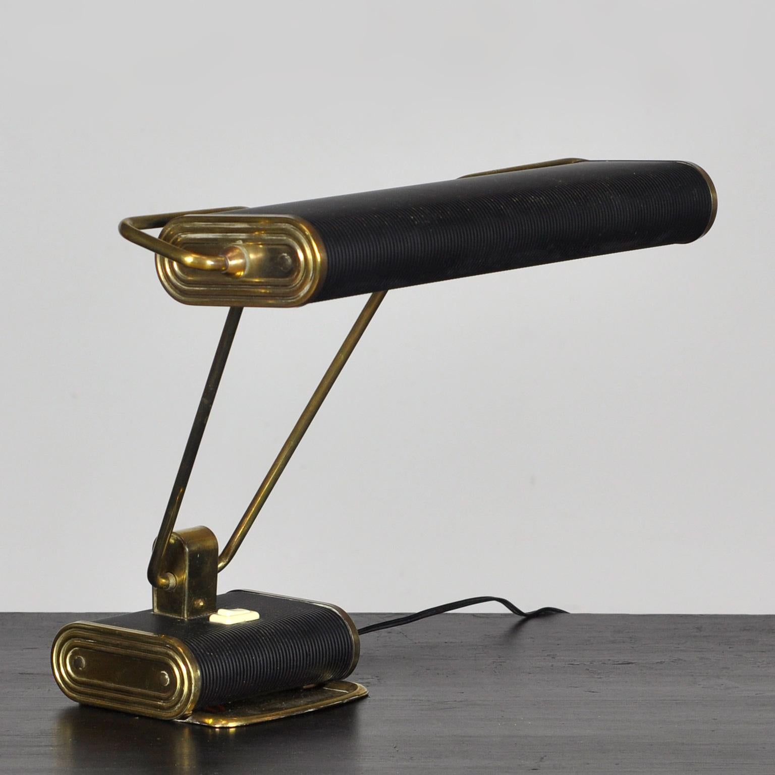 Fantastic brass and black metal desk lamp n°71 by André Mounique produced by Jumo in France ca. 1940s.
The lamp consists of corrugated steel and the original black-painted and chromed brass pipe. The long double arm can be tilted forward as well as