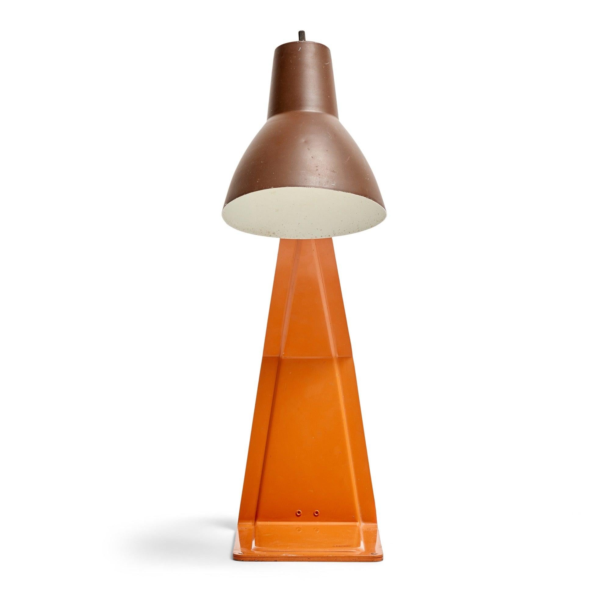 A desk / table lamp made of a singular stamped, die cut and folded piece of metal with a pivoting shade.