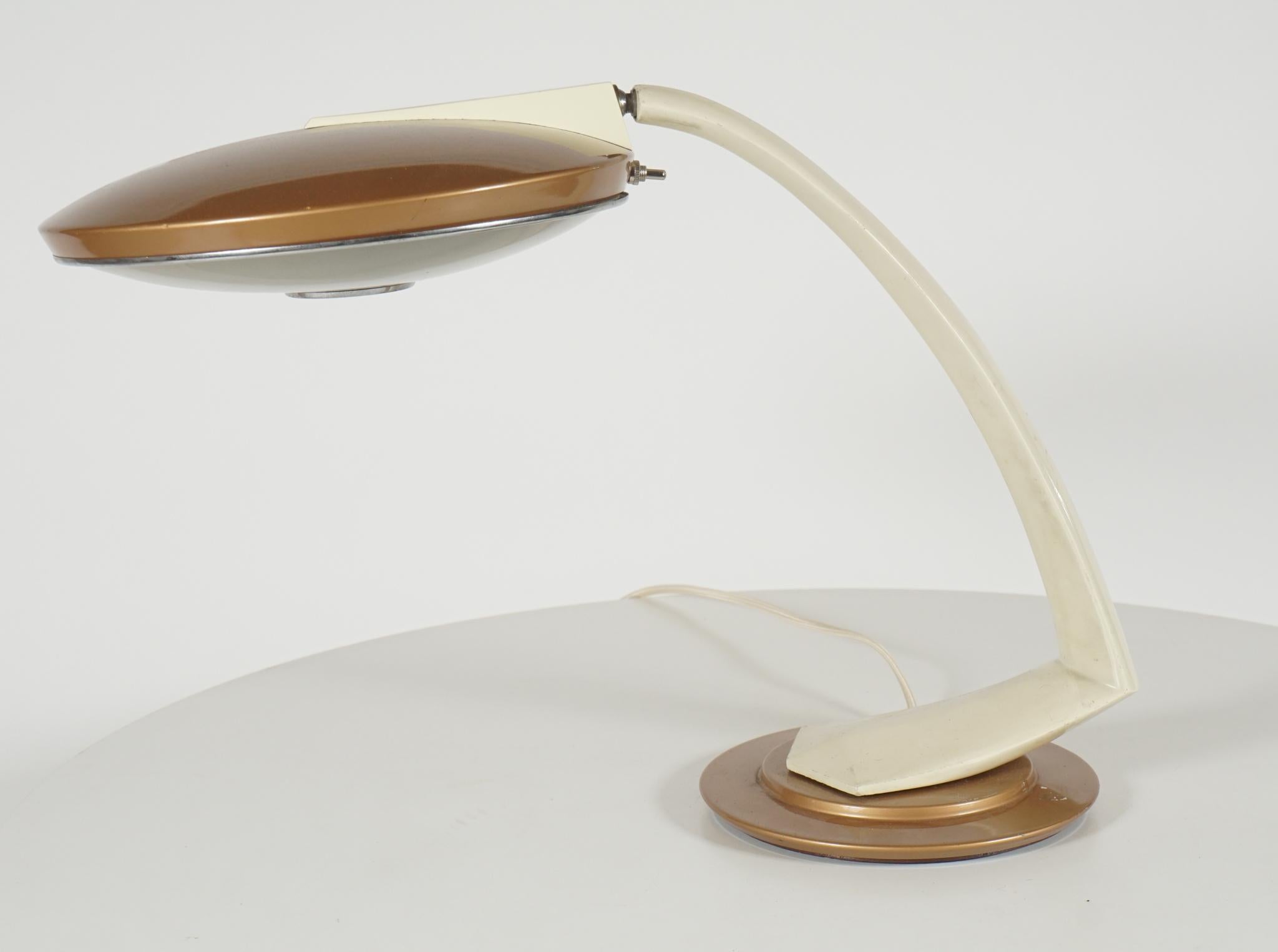 Midcentury desk lamp with 360 degree, revolving feature. Disk shaped light also has a 360 degree rotation cream colored arm and base. Copper
Top, light with diffuser covering bulb.