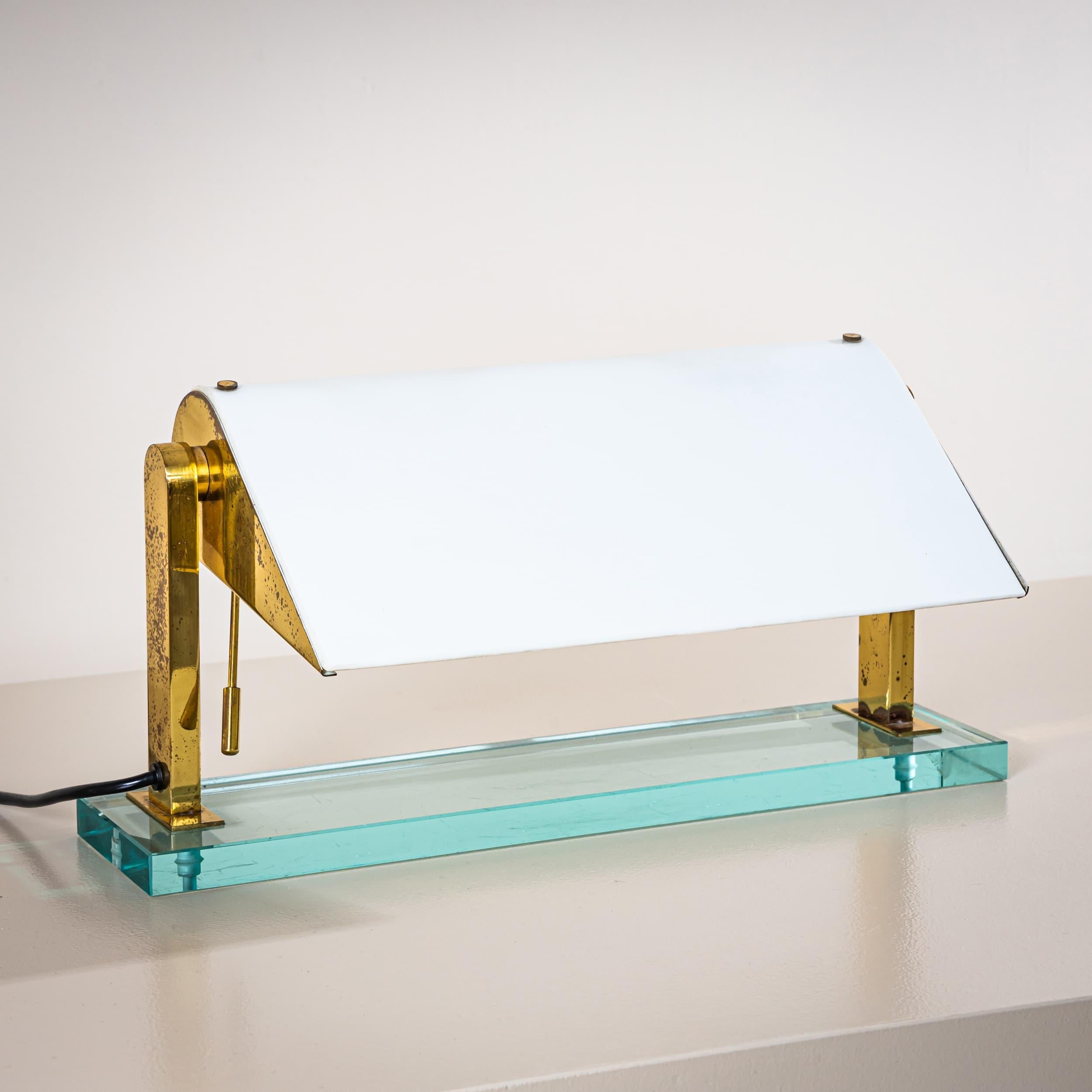 Rare lampe de table, modèle 0836, dessinée par Pietro Chiesa pour Fontana Arte, conçue en 1939. La lampe repose sur une base rectangulaire en verre teinté bleu. Un support en laiton raffiné maintient l'abat-jour réglable à la finition laquée blanche