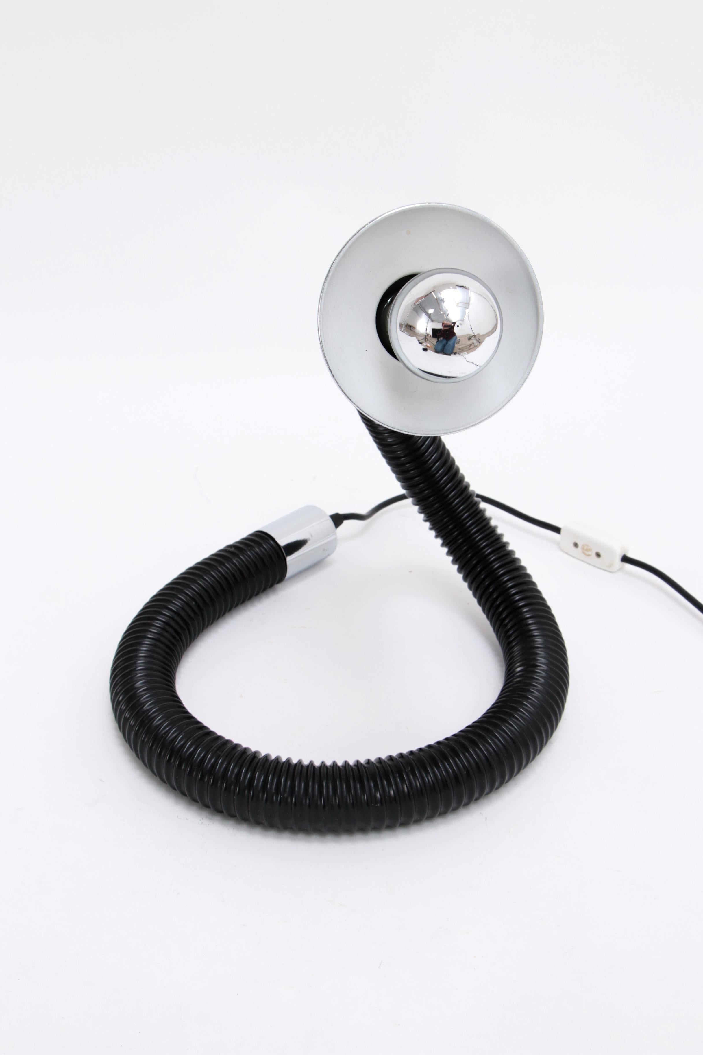 Hillebrand Desk lamp Model Snake with beautiful chrome shade, 1970
 
Can rotate in various positions and turns.

Very flexible hose with a nice chrome cap at the end, also nice if you put a silver head mirror light in it. 
If you are looking for a