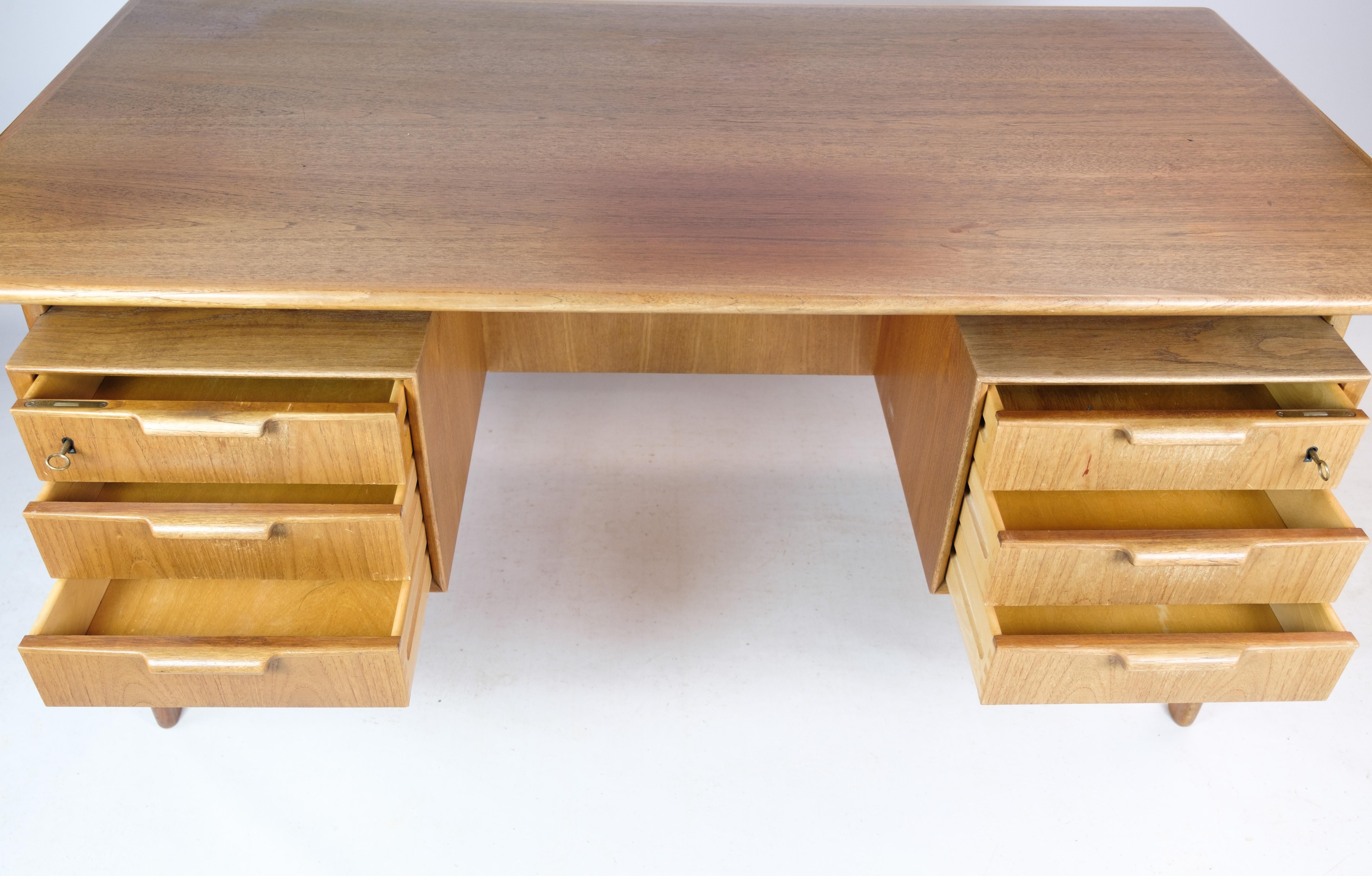 Model 75 desk, a timeless piece designed by Gunni Omann and crafted by Omann Junior Møbelfabrik around the 1960s. This desk is a testament to exquisite craftsmanship and design ingenuity. Made from incredibly beautiful light teak wood, it exudes
