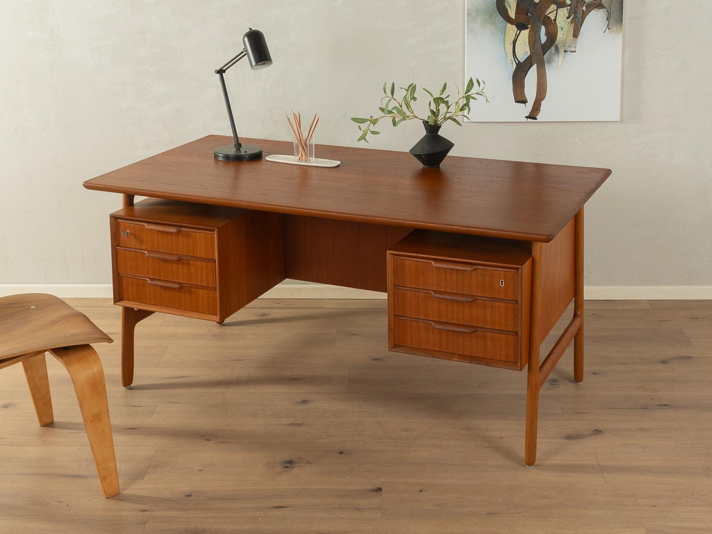 Classic freestanding desk model Nr. 75 from the 1960s by Omann Jun. High-quality corpus in teak veneer with a floating table top, six drawers, a hinged door and two bookcases on the rear and solid wood legs.
Quality Features:

    accomplished