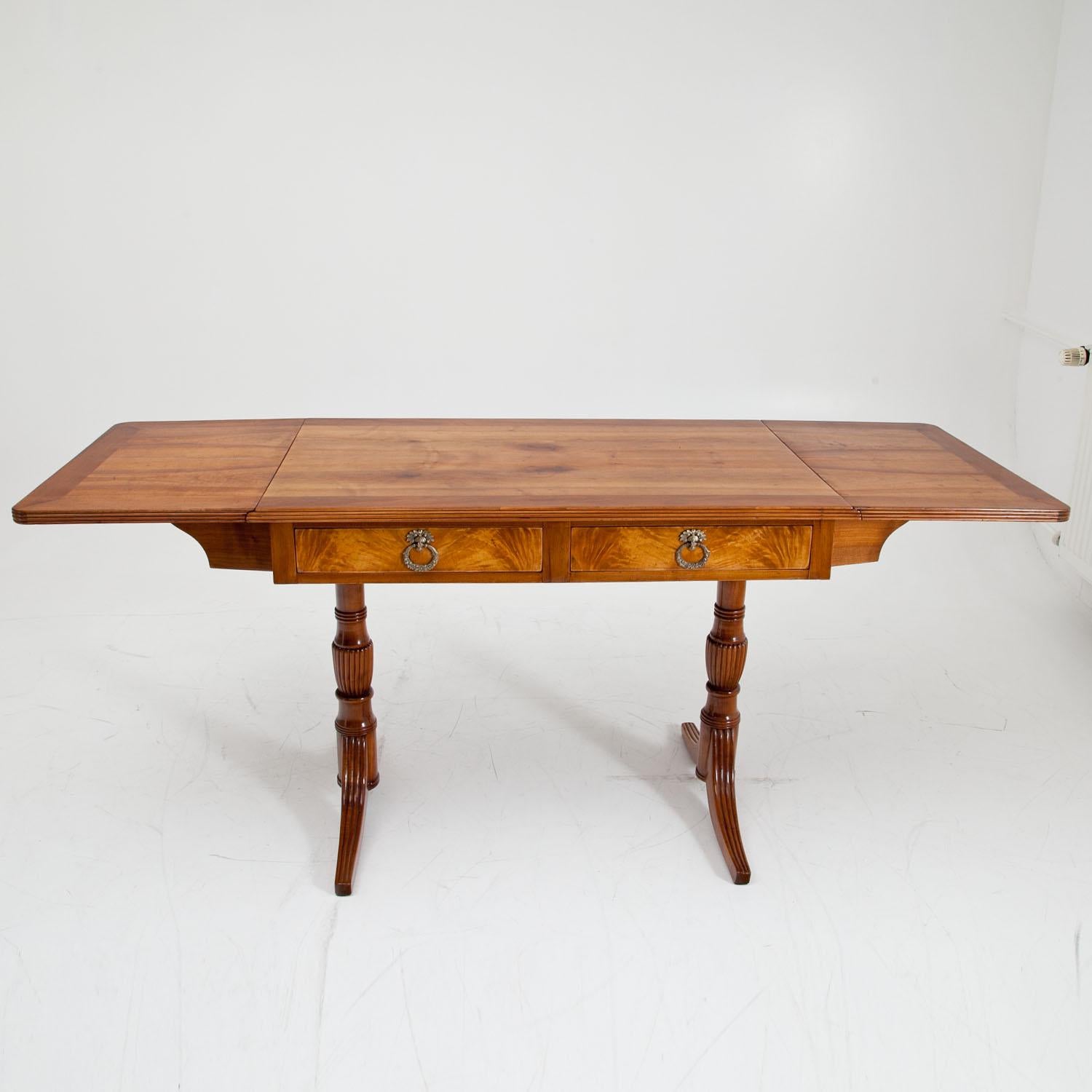 English style cherry Desk from Northern Germany with two drawers, standing on vase-shaped legs with groove decorations. The tabletop has a total length including the folds of 94 cm. The back shows blended drawers in the same style as the front.