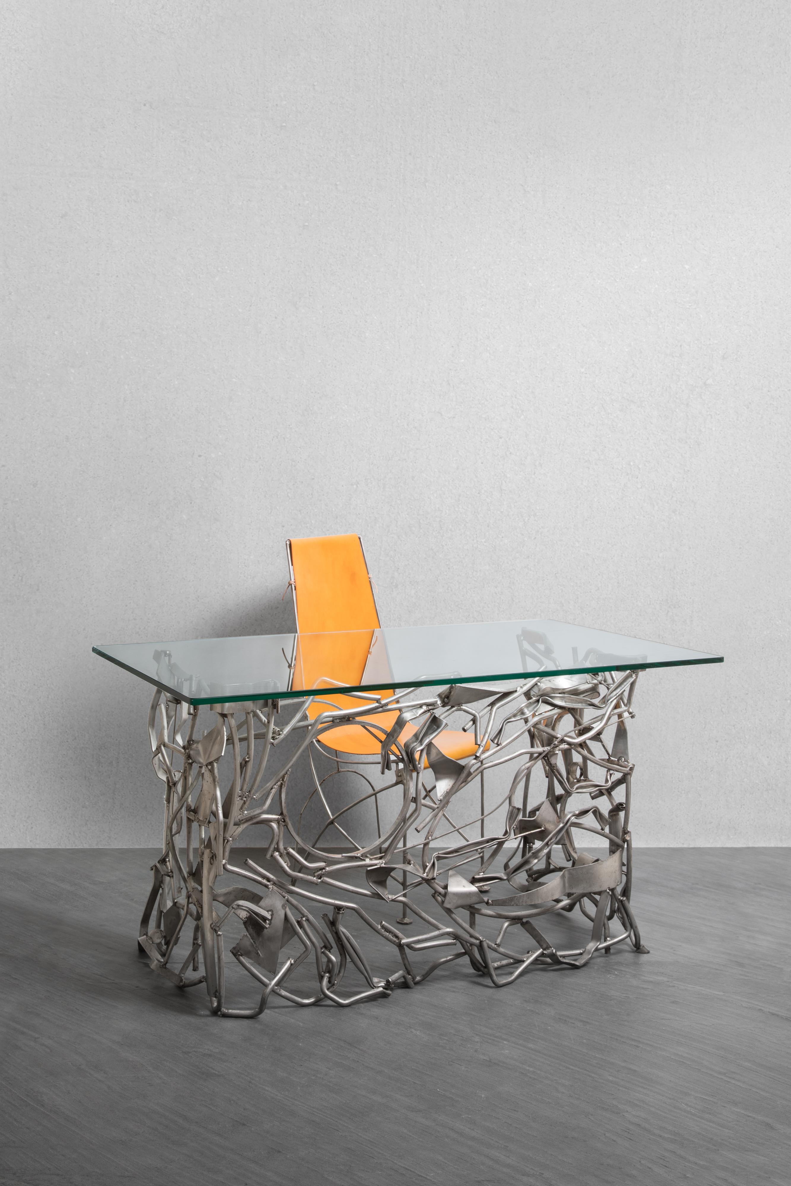 Little desk or console, composed of folded and entangled metal tubes. Rectangular glass slab.