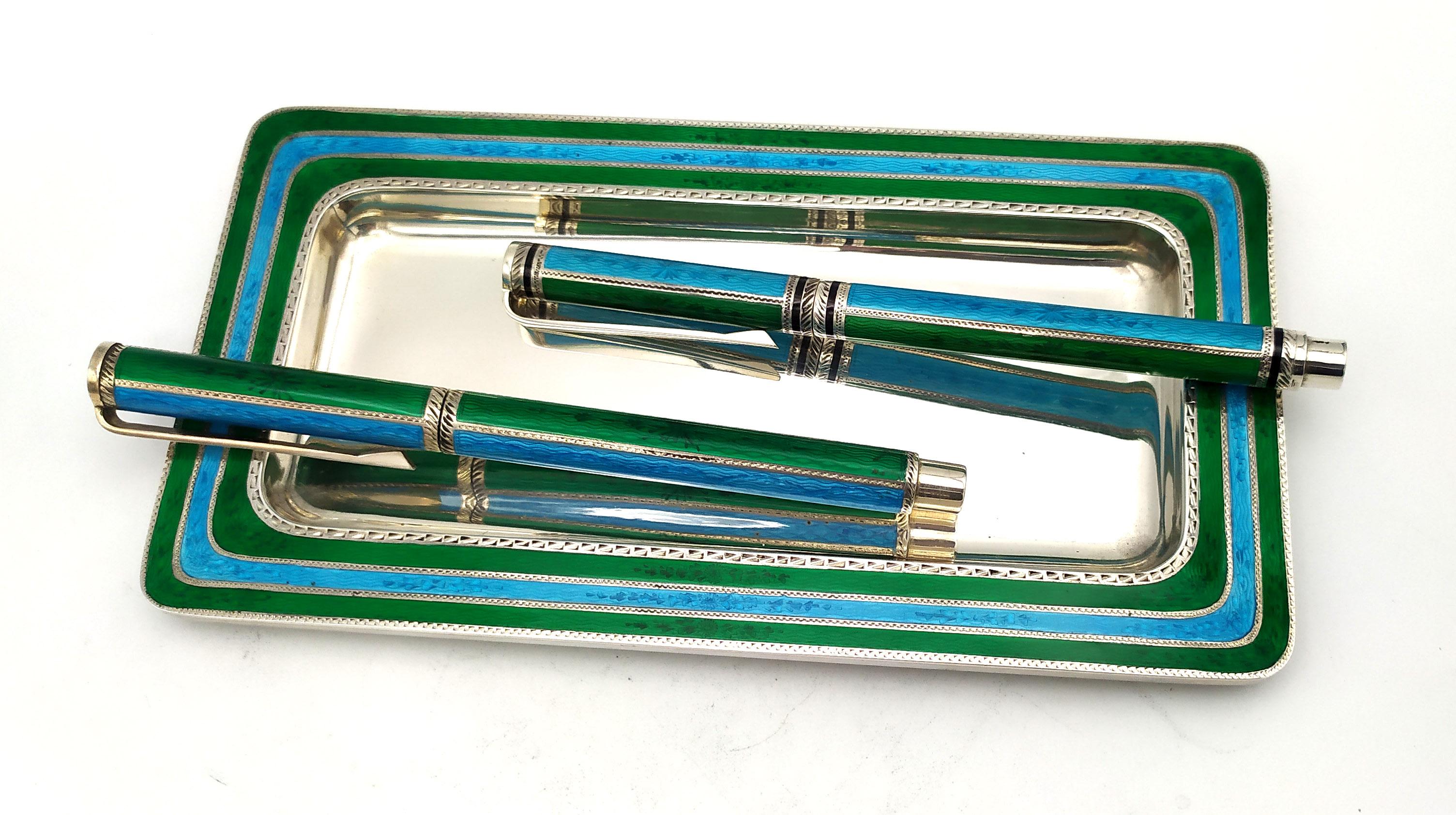 Rectangular tray with rounded corners in 925/1000 sterling silver with translucent fired enamels with two-tone stripes on guilloche and hand engravings, cm. 9.5 x 18. For fountain pen (4568-5201) with 18k gold nib and ink cartridge and for ballpoint