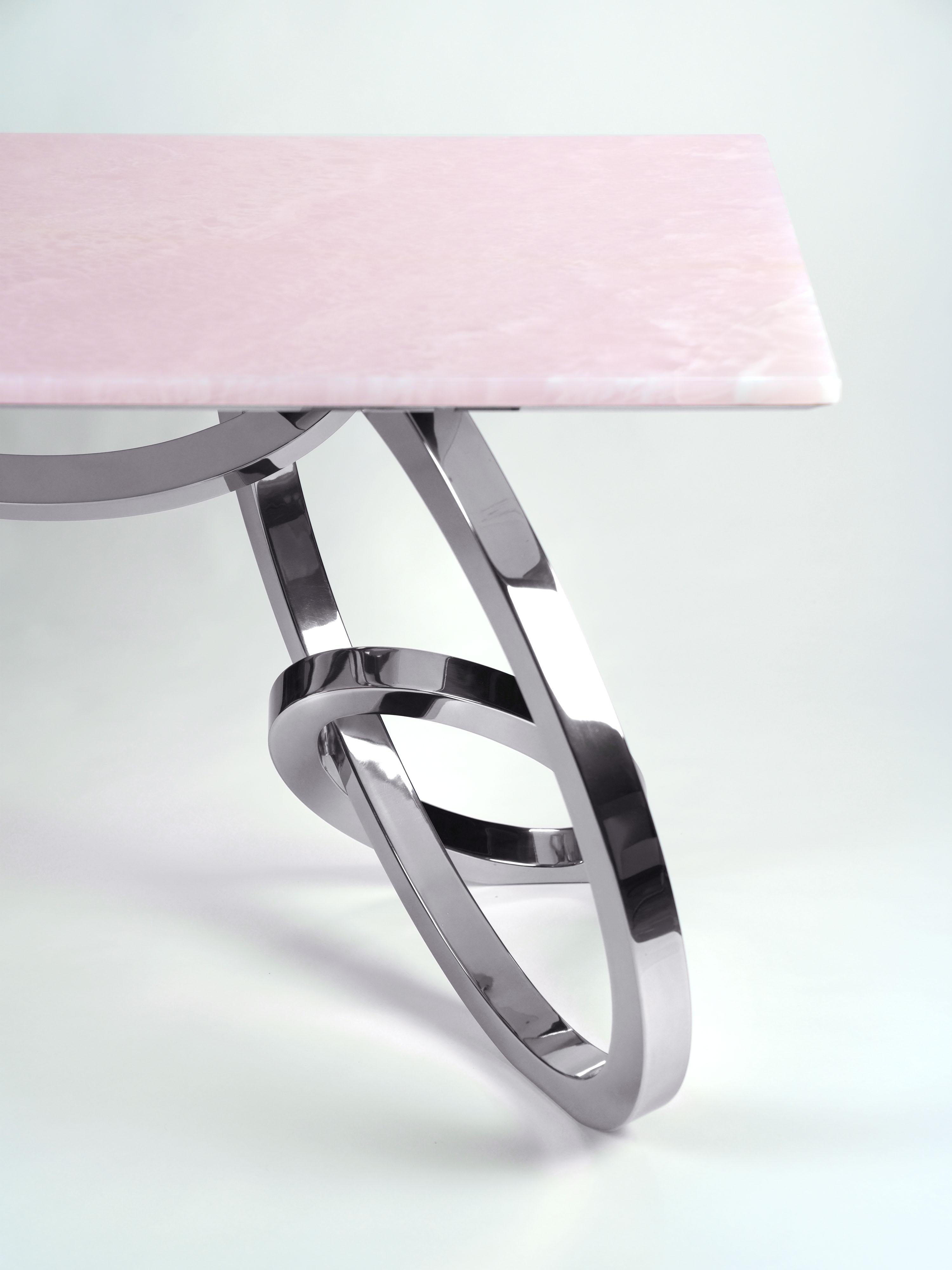 Der 'Bangles Desk' ist ein wichtiger Schreibtisch mit einer Struktur aus hochglanzpoliertem Edelstahl und einer Platte aus seltenem rosa Onyx. Jeder einzelne Armreif wird von Hand geschweißt und hochglanzpoliert. Die spiegelnde Oberfläche des Stahls