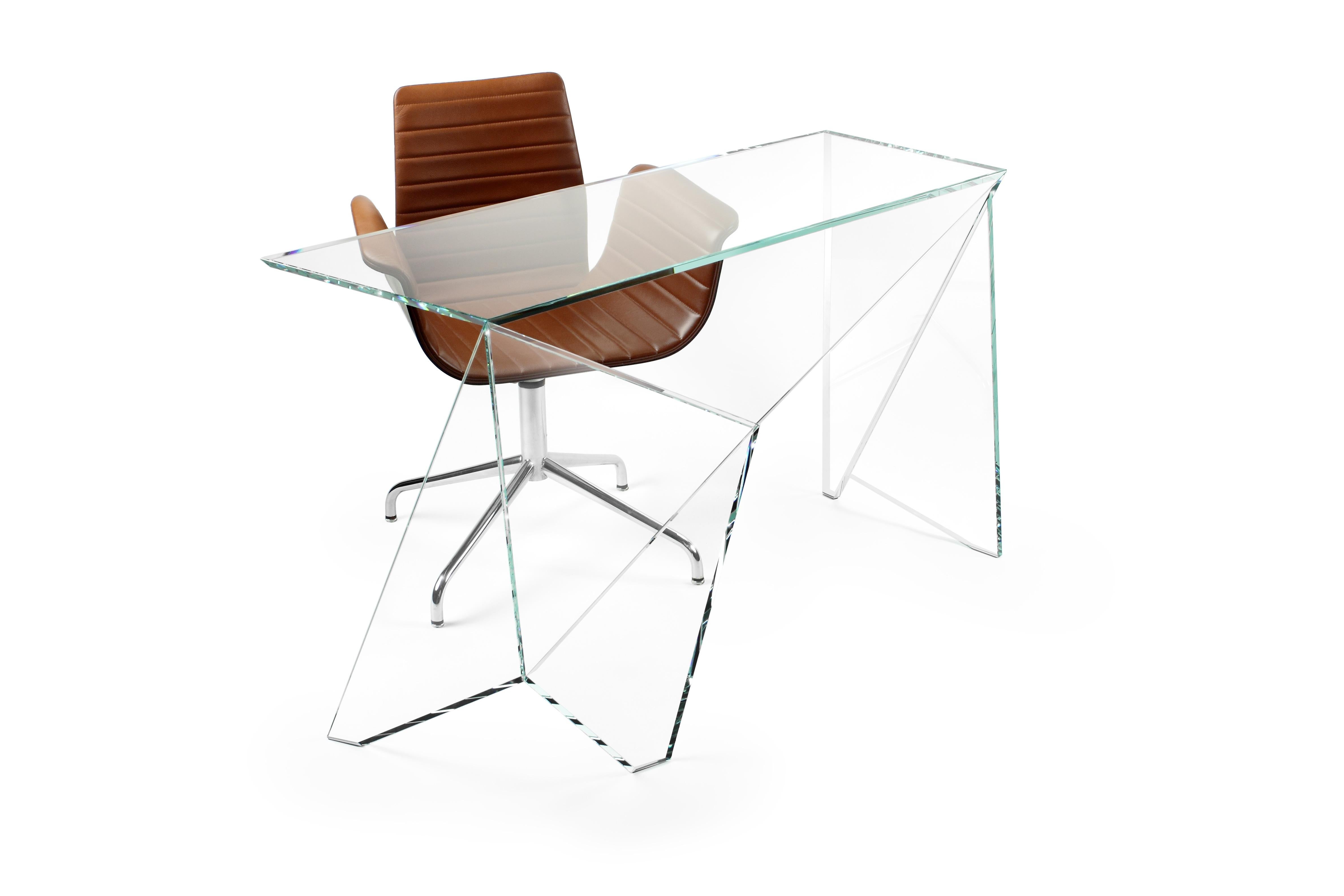 The desk 'Origami' is made of extra-clear crystal glass. Each sheet of extra-clear crystal glass is cut and ground with extreme precision, then the sheets are assembled by hand, having to fit together perfectly, the gluing operation requires extreme
