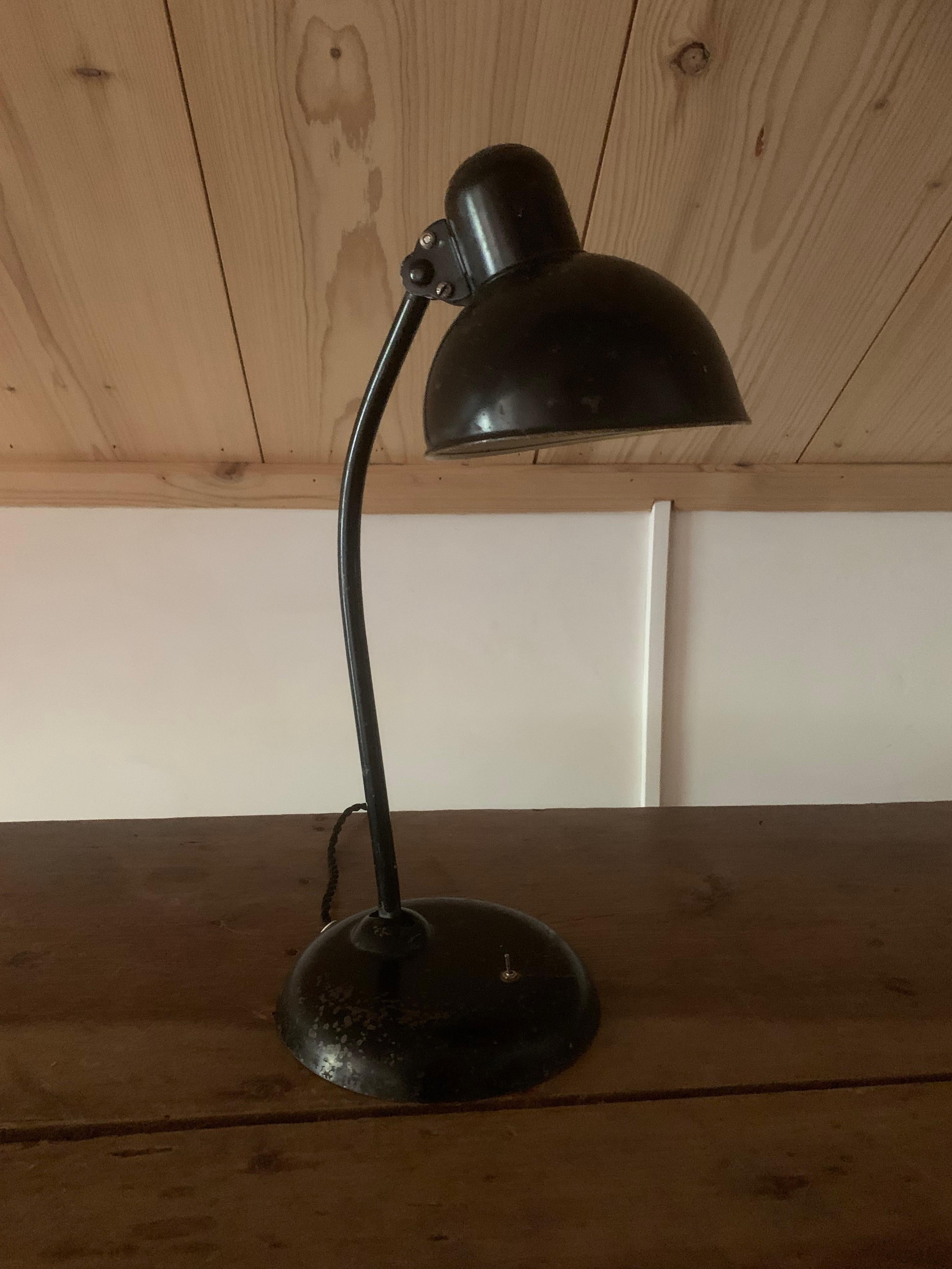 Eine verstellbare Schreibtischlampe aus schwarz emailliertem Stahl. Design von Christian Dell für Idell Kaiser Deutschland, ca. 1930er Jahre.
Originalzustand, der Schalter wurde ersetzt und neu verkabelt.