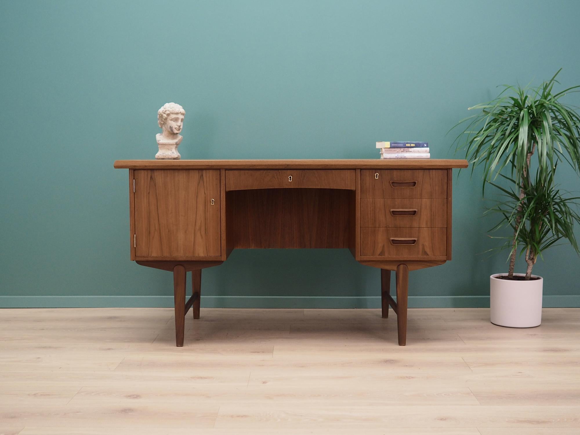 Desk made in the 1960s, Danish production.

The structure and top are covered with teak veneer. The legs are made of solid teak wood. The surface after refreshing. The front of the desk has four drawers and a cabinet. It has a key to locks, locks