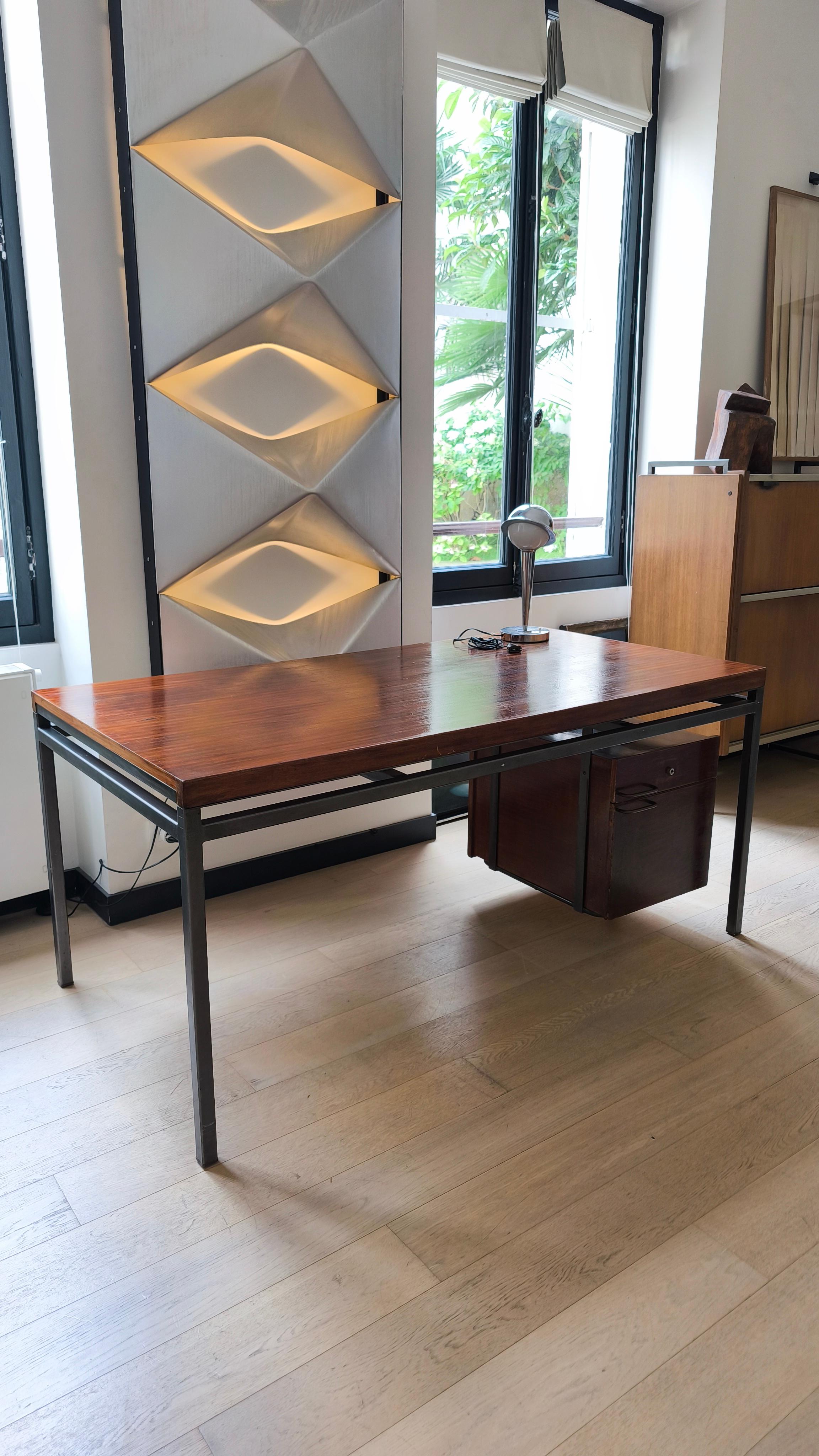 Rare bureau de direction, Georges Frydman EFA.

Il semble être en placage de bois de rose, datant des années 1960.

Ce bureau se compose d'un grand plateau, d'un meuble contenant un tiroir et d'un caisson.

Le cadre métallique est en acier gris.

La