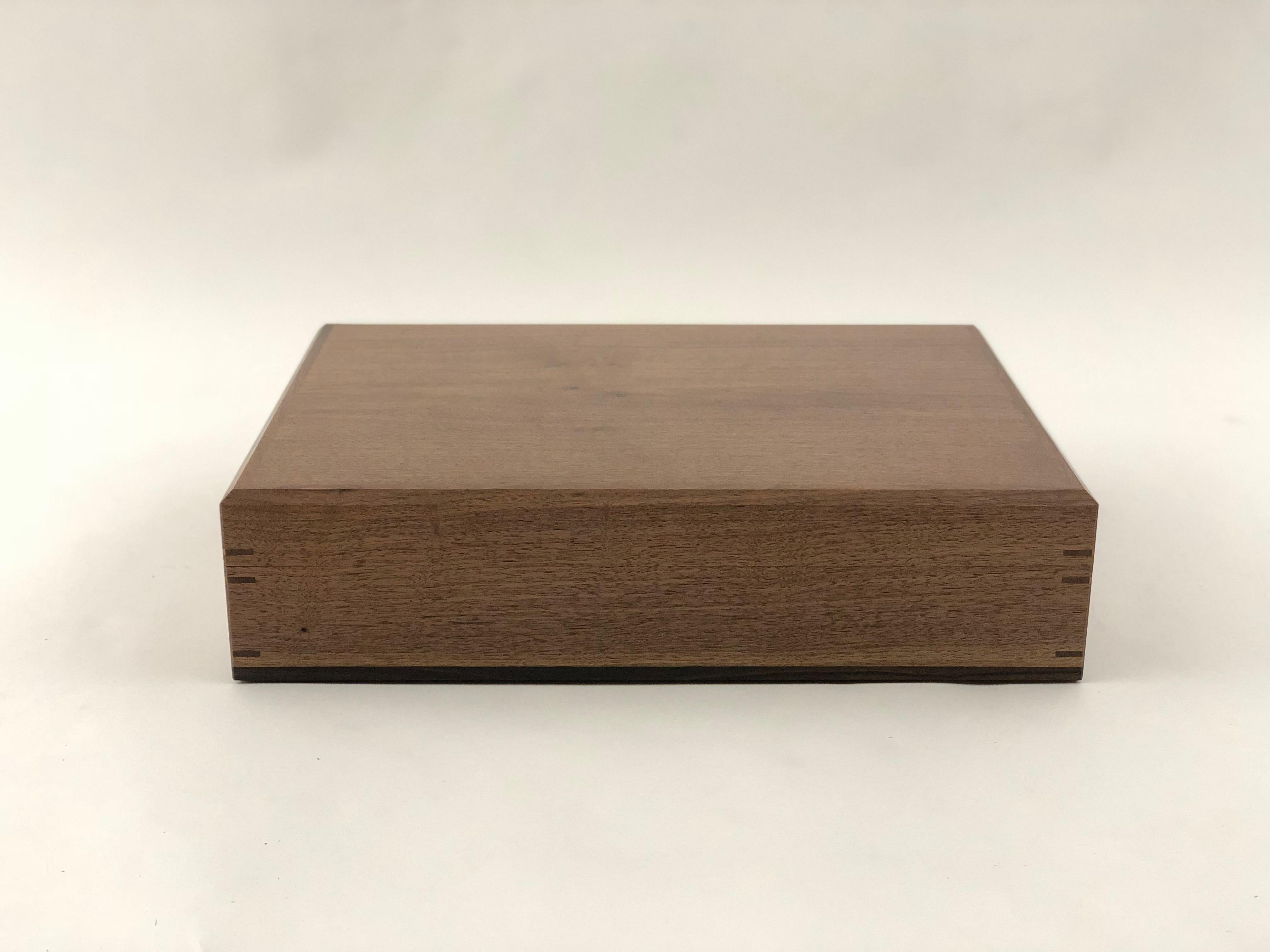 Desktop humidor in walnut and ebony. Interior liners in Honduran mahogany. I use Honduran mahogany in the construction of my humidors because it does not impart a flavor and because it is an exceptionally high quality material with the ability to