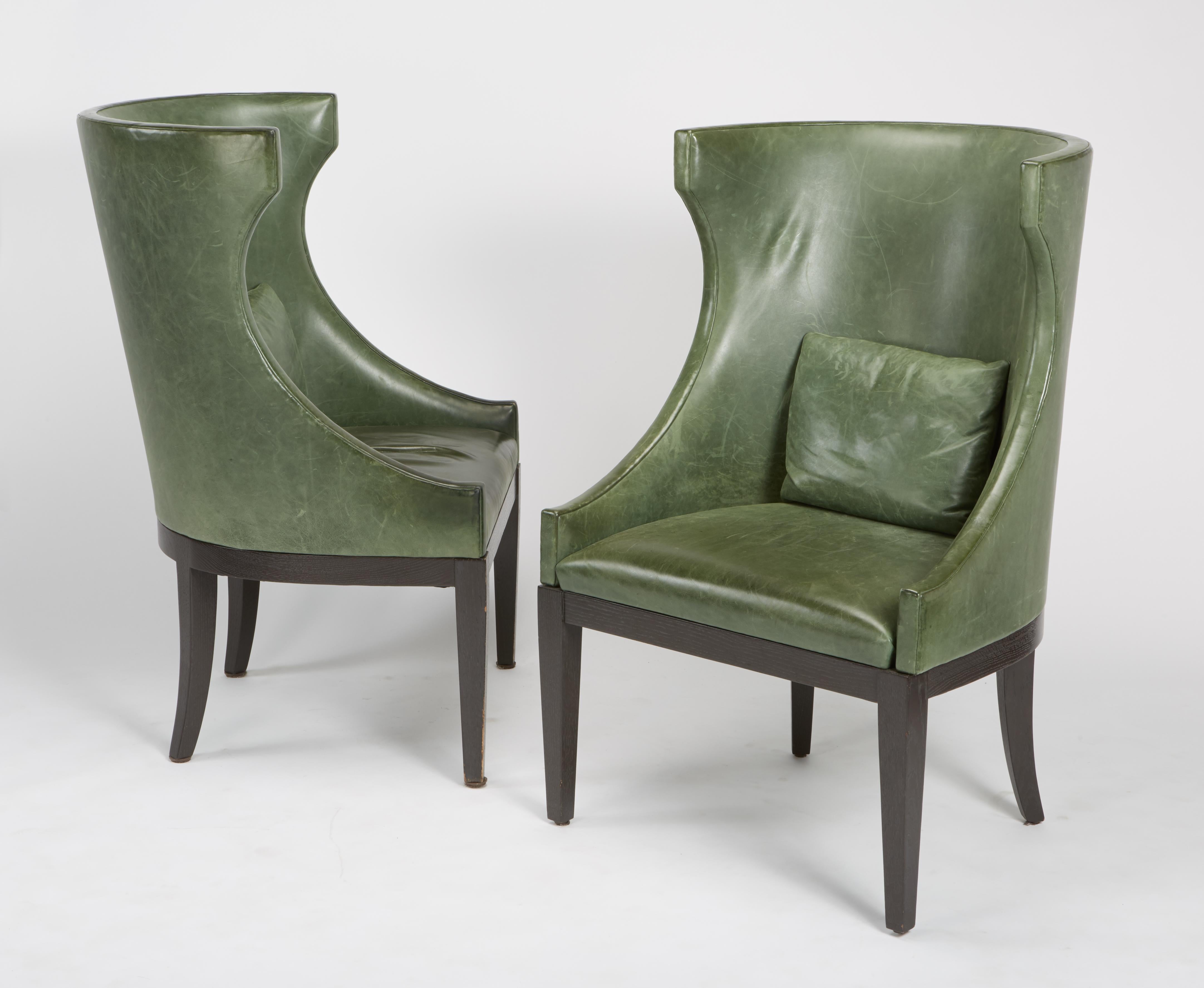 Finely crafted pair of high wing back club chairs by Dessin Fournir with classical modern form, having distressed leather from Garrett Leather with back cushions on ebony stained frame and legs, circa 2004. Leather shows wear and age. Legs may have