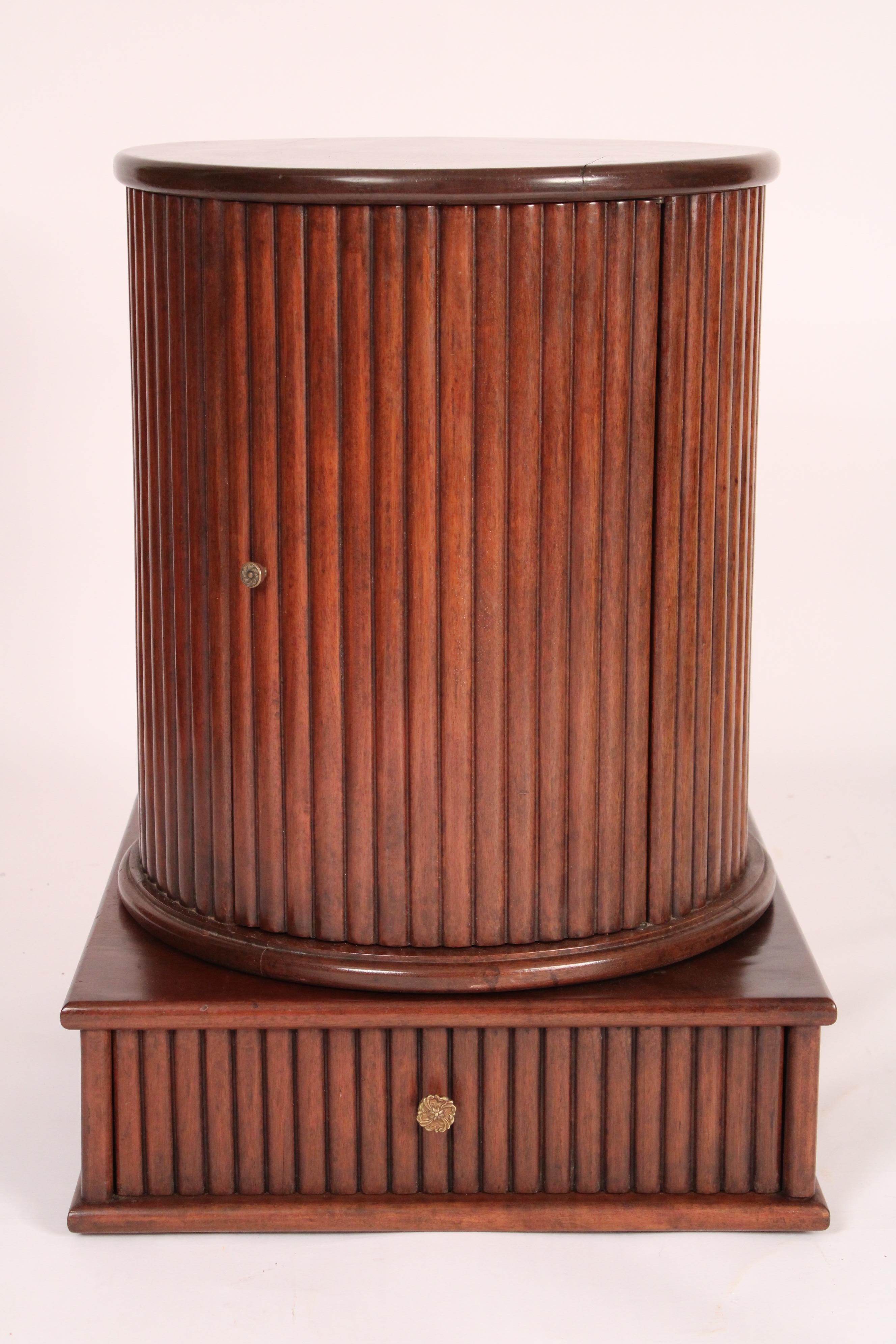Dessin Fournir neo classical style mahogany cylinder form occasional table, late 20th century. Having a circular single board top with rounded edges, a reeded column with door, resting on a square base with a drawer. Diameter of top 20
