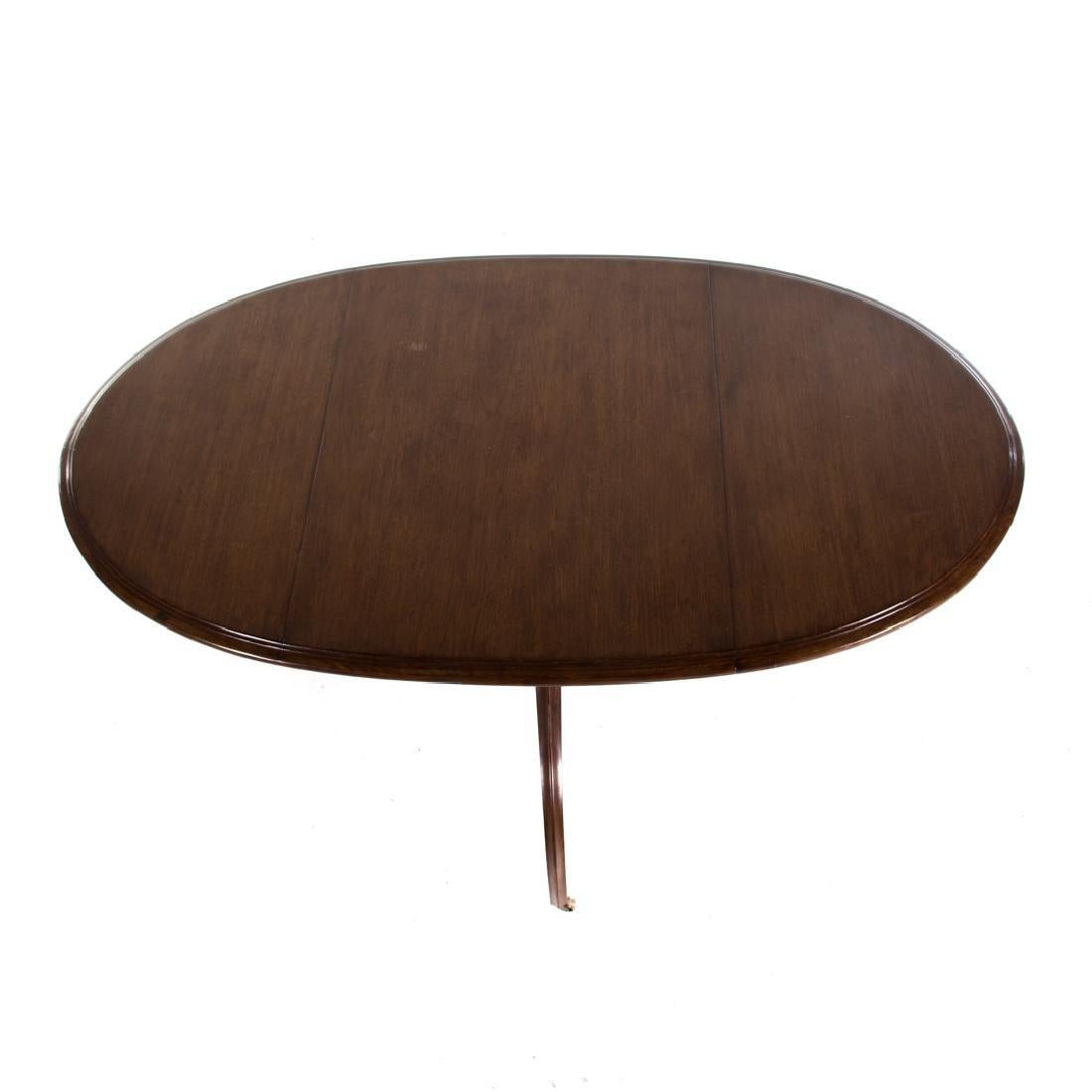 A Regency style oval-top table by Design Fournir. The oval top rests on a single column that splays into three legs, each with a caster.
21st century; 60 in. L. oval top with one false leaf, 29 1/2 in. H., 36 in. W.

Condition
Please see the