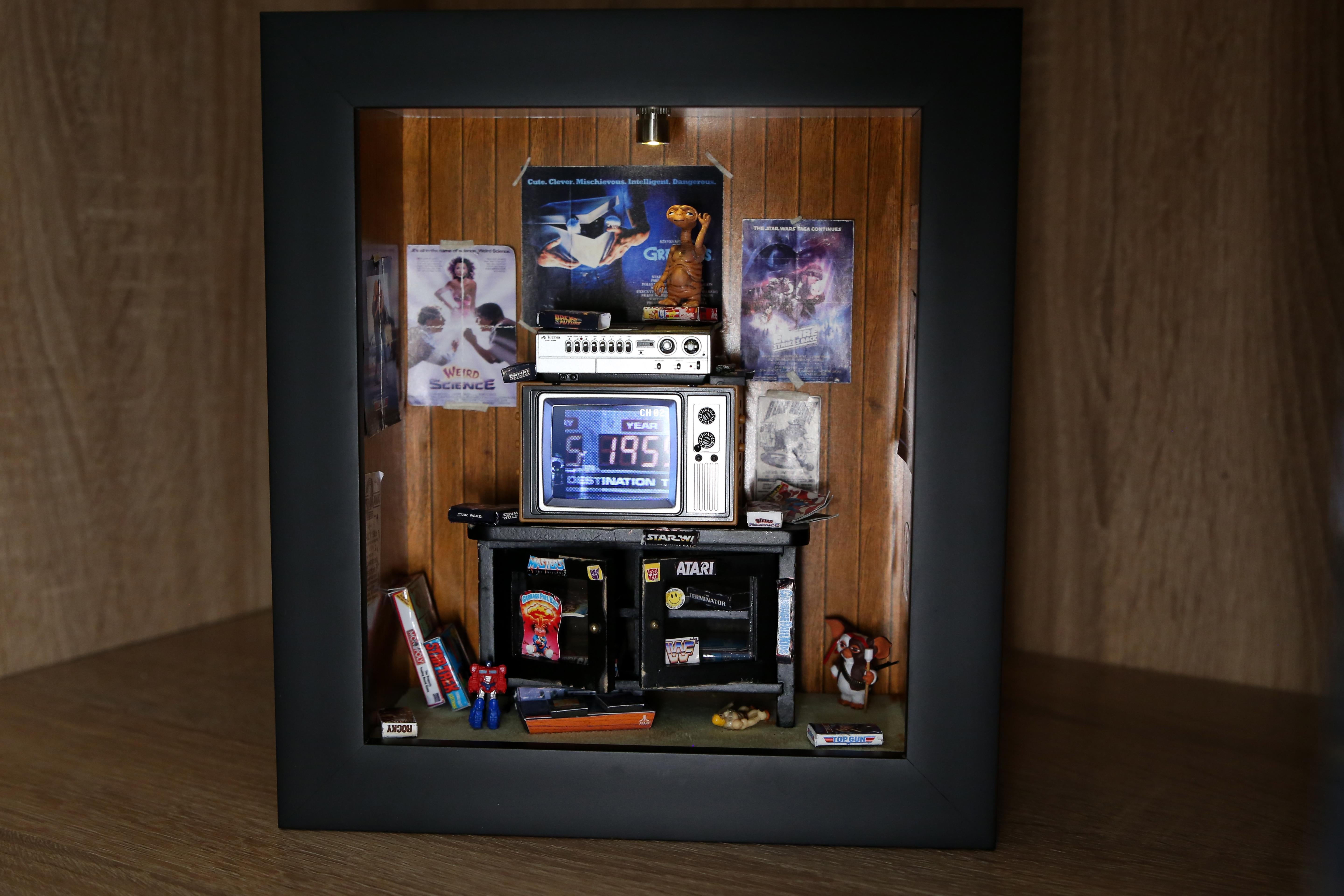 MINIATURE GEN X ROOM CASE STUDY -001-PG-13
Transport yourself back to 1988 with this handmade room box featuring:
-Working T.V. w remote playing movie clips from Back to the Future (licensed by Universal)
-Handmade 80's movie posters. Distressed by
