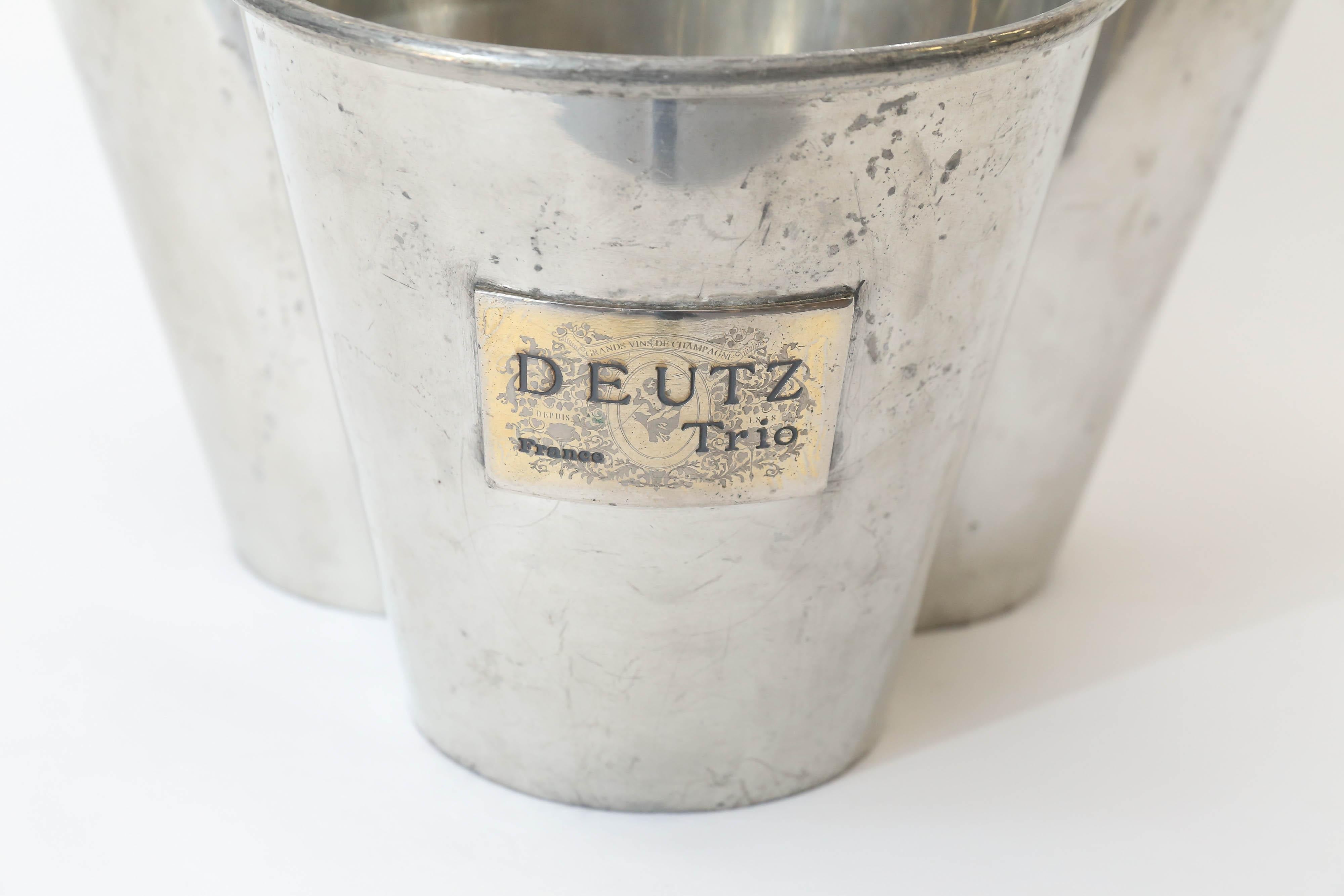 From France, a trio champagne cooler in hotel silver, joined together and decorated with brass plaques. Unique and useful, from the House of Deutz.