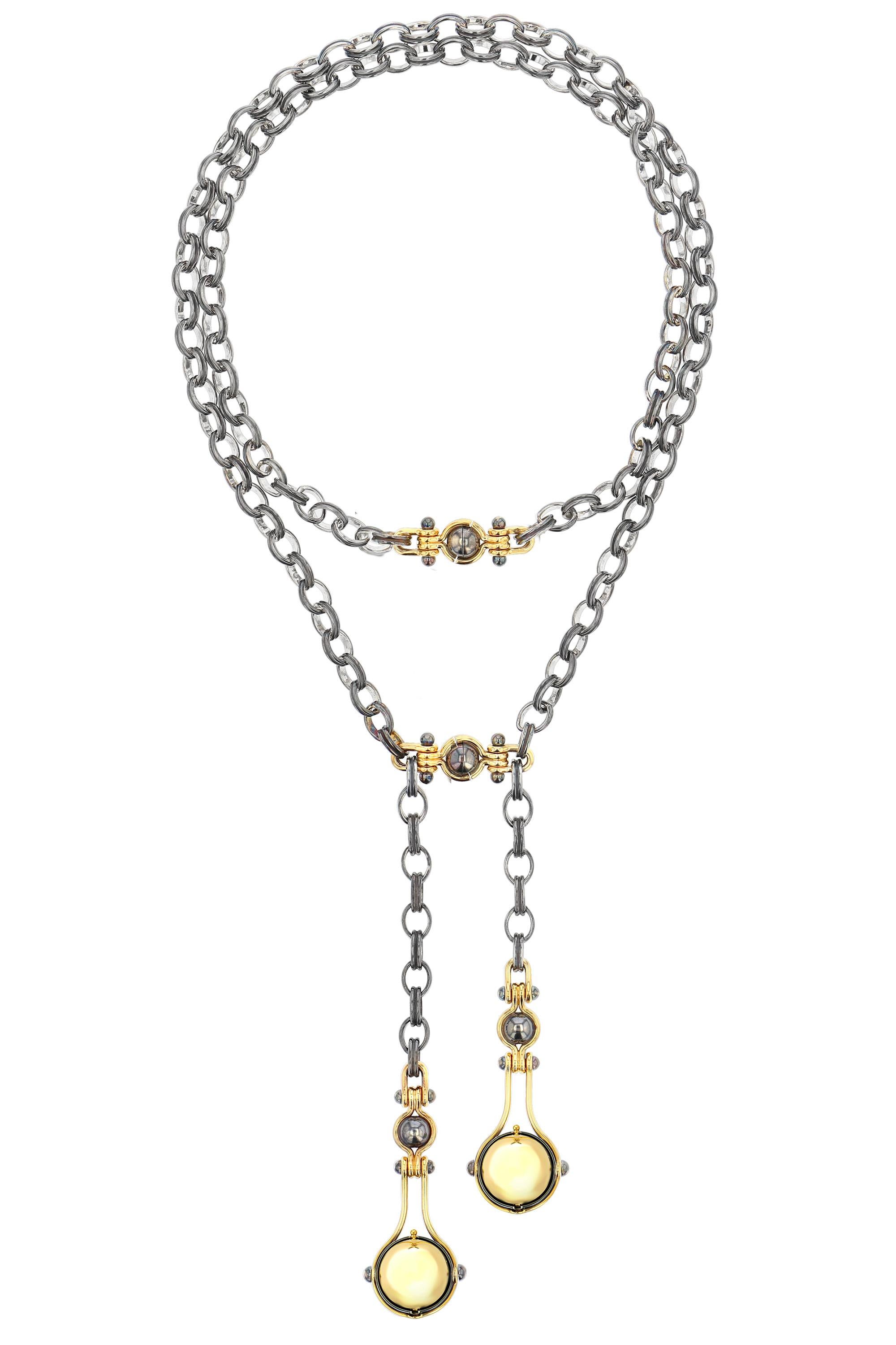 Halskette in Gold und Silber. Drehbare Kugeln: eine enthüllt eine Akoya-Perle, die mit einem Diamanten besetzt und von einem Ring aus Weißgold umgeben ist; die andere enthüllt eine Kugel aus Gelbgold, die einen Planeten aus weißen Diamanten