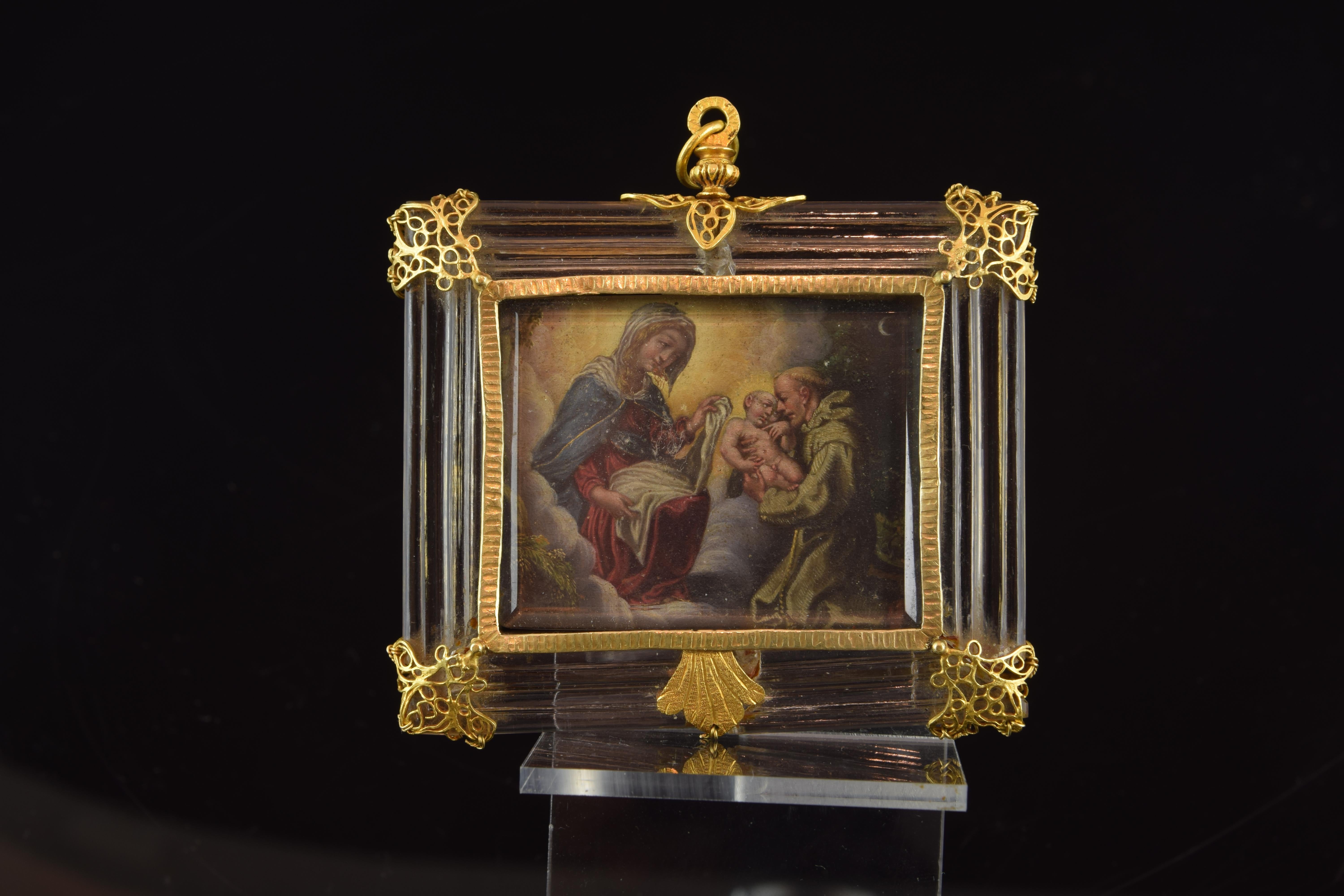Devotional pendant showing a figurative scene with Saint Anthony of Padua receiving the Child Jesus from the Virgin Mary, around which a gold band with fine grooves has been placed to further enhance the carved rock crystal frame with fine moldings.