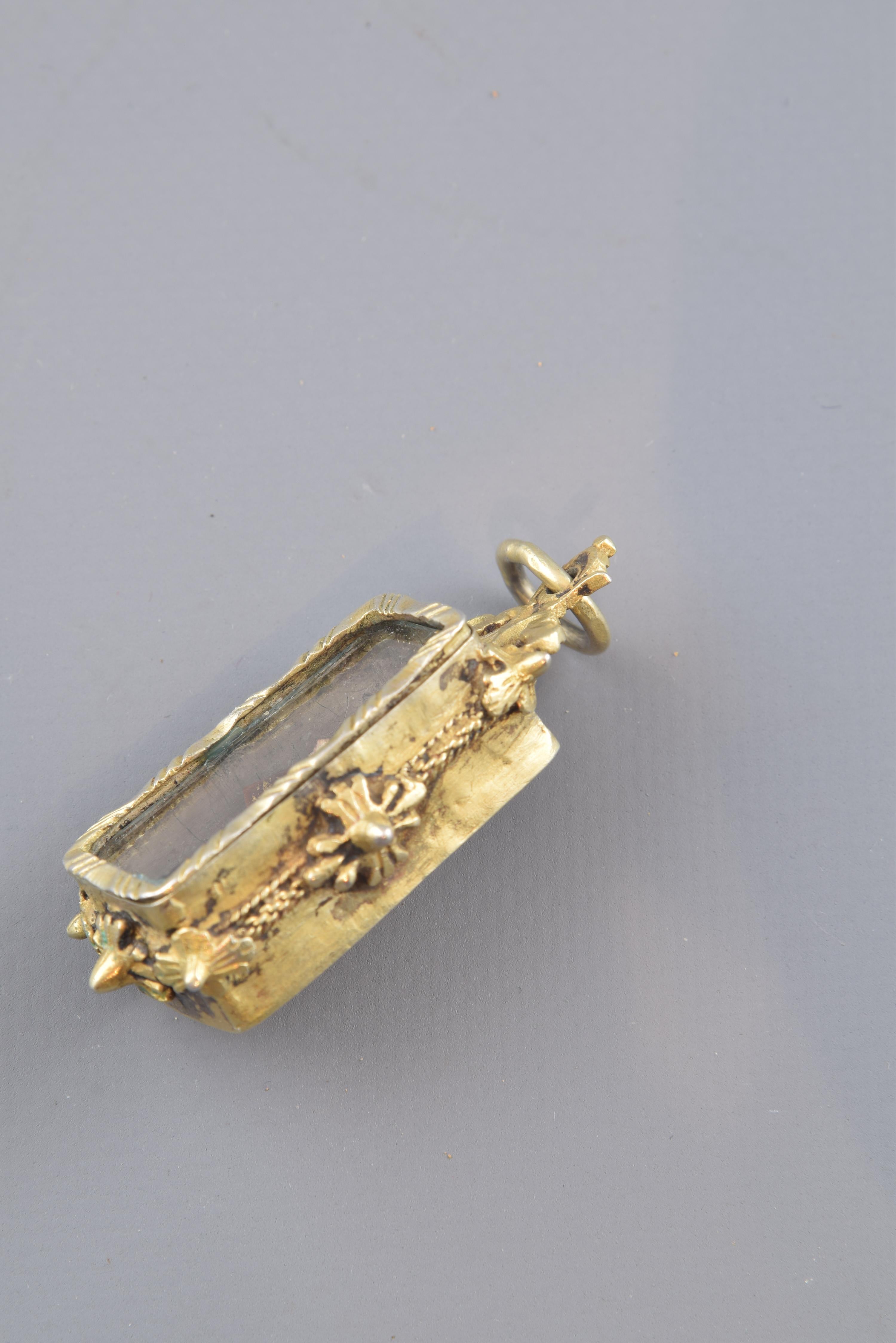 Devotional pendant in the shape of a chapel or altar, with a rectangular elevation decorated to the exterior with a series of lines grouped in trios and arranged diagonally to the vertical of the jewel frame, vegetal motifs on the upper part