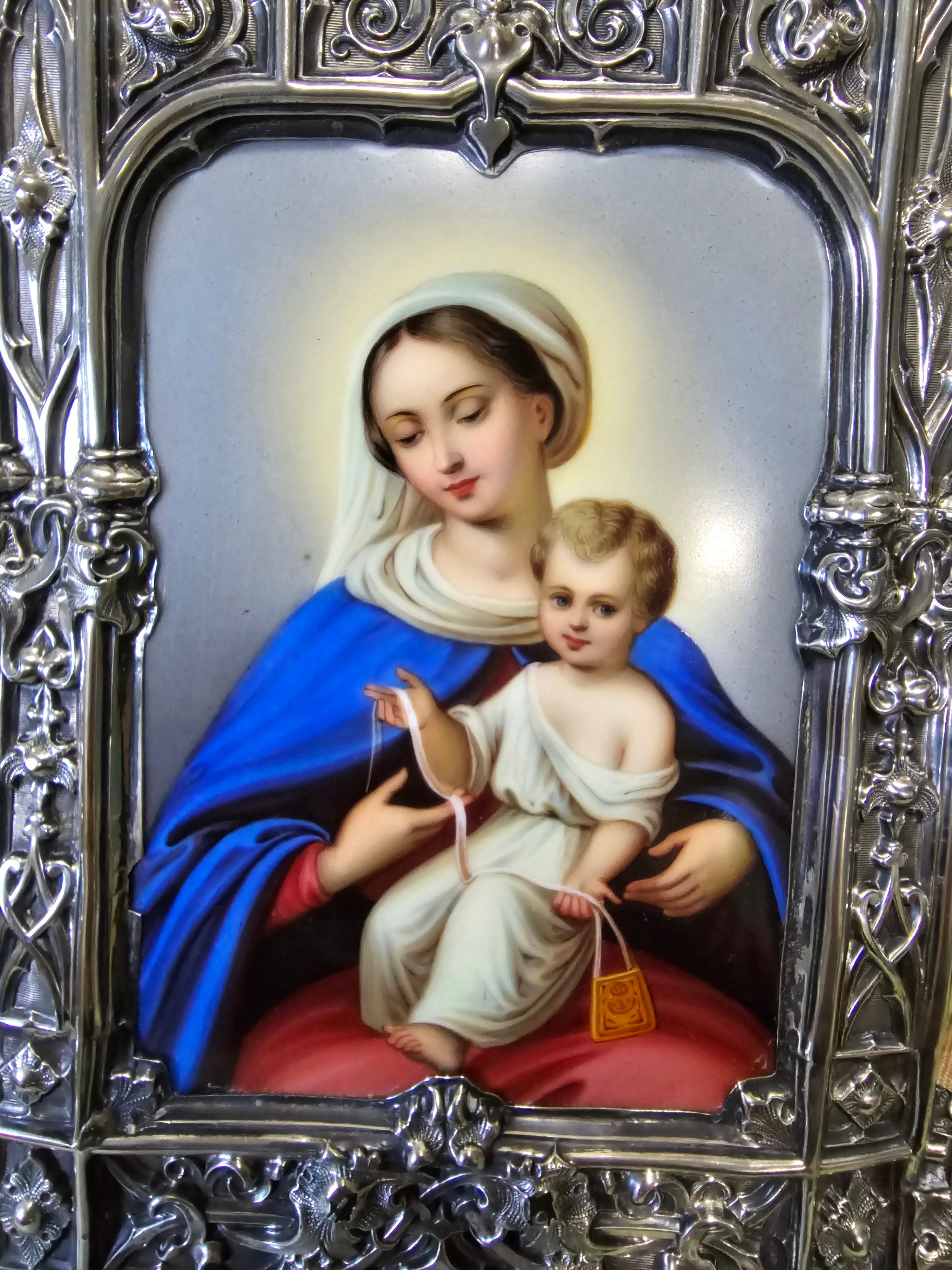 Entdecken Sie diese prächtige Andachtstafel mit der Darstellung der Jungfrau Maria und des Jesuskindes, die mit einer bemerkenswerten Emaillierung versehen und in einen Silberrahmen eingefasst ist. Dieses Werk von großer künstlerischer Finesse