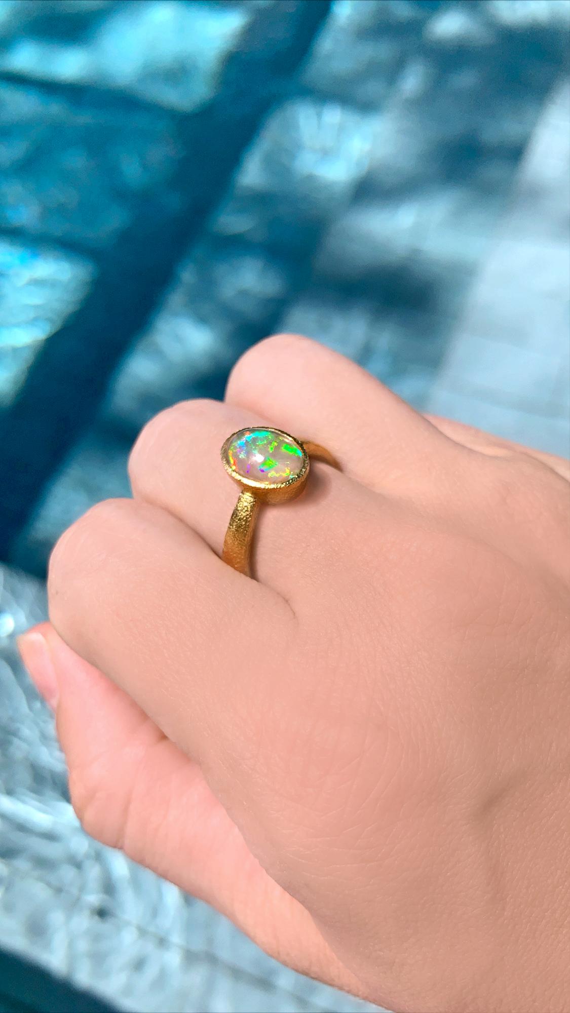 One of a Kind Ring by renowned jewelry maker Devta Doolan featuring an extraordinary, top quality Mexican crystal opal, electrified from within by a full spectrum rainbow flash. The gem opal is bezel-set in the artist's signature-finished 22k yellow