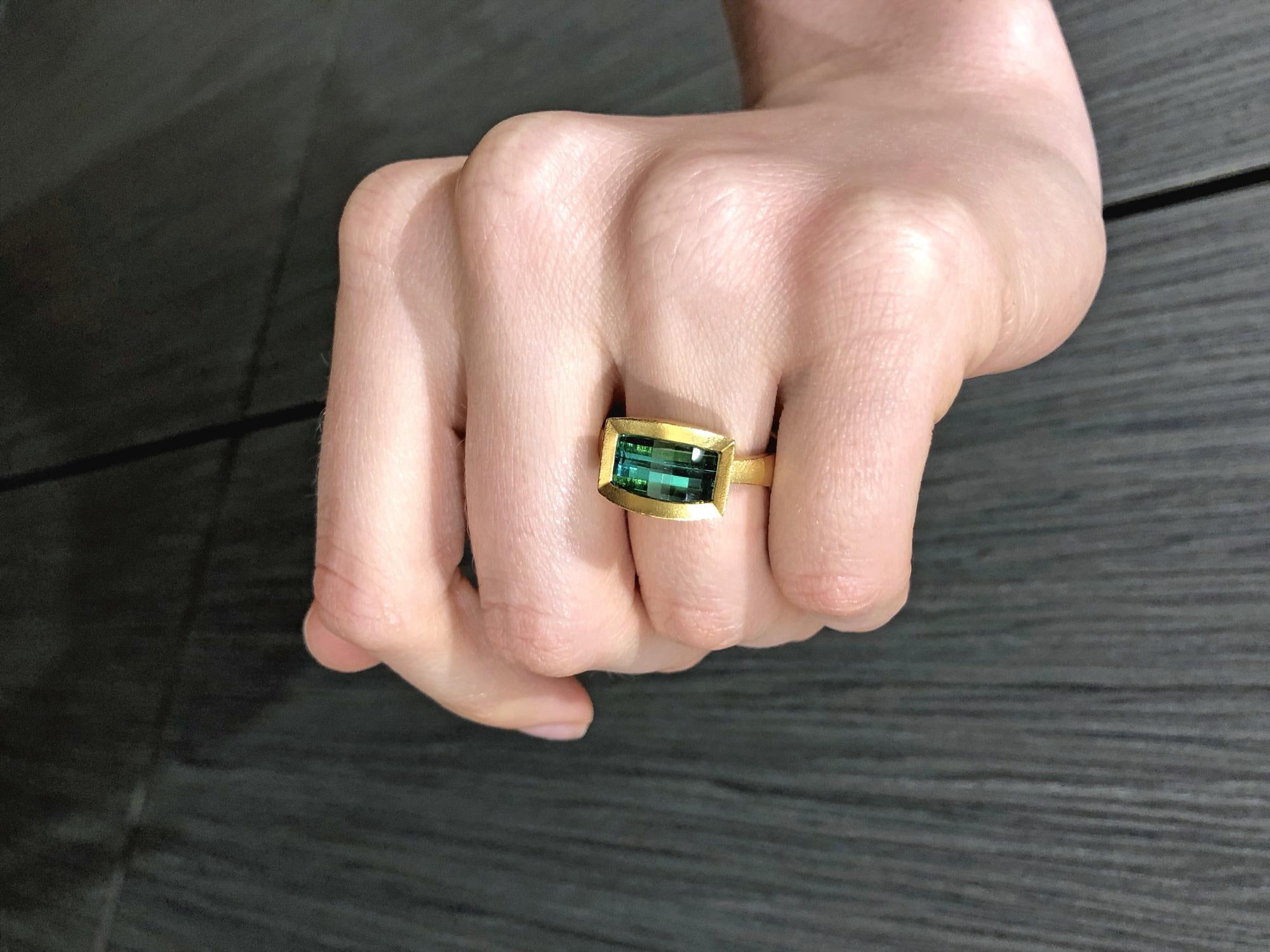 One-of-a-Kind Ring handcrafted by jewelry artist Devta Doolan in his signature 22k yellow gold finish with a horizontal bezel-set bluish-green tourmaline custom-cut with a shimmering geometric grid. Spectacular color and cut. Size 6.25 (Can be