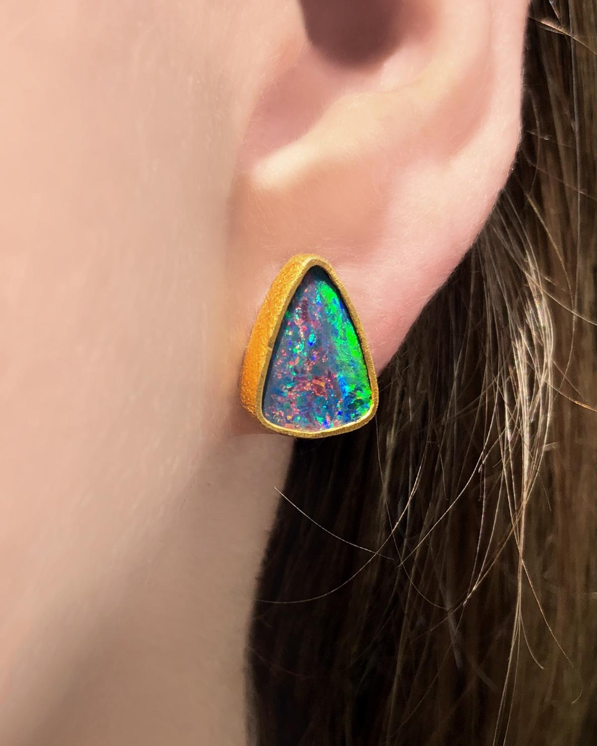 One of a Kind Stud Earrings handcrafted by acclaimed jewelry designer Devta Doolan, with violet blue opal doublets exhibiting a vibrant multicolored confetti flash with electrifying green, orange, blue, yellow, violet, and purple fire. The opals are