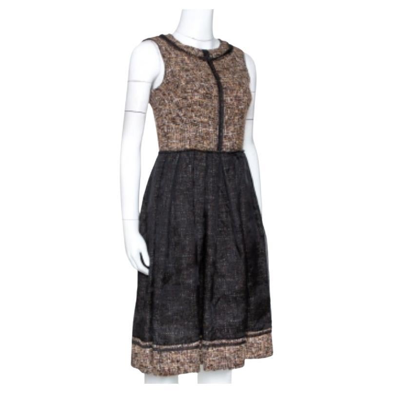 Fusion exquise de classe et de grâce, cette robe D.G. vous apportera un style infini. Cette pièce n'est rien d'autre que de l'élégance à l'état pur. Conçue dans une silhouette évasée, cette robe en tweed présente une taille froncée et une fermeture