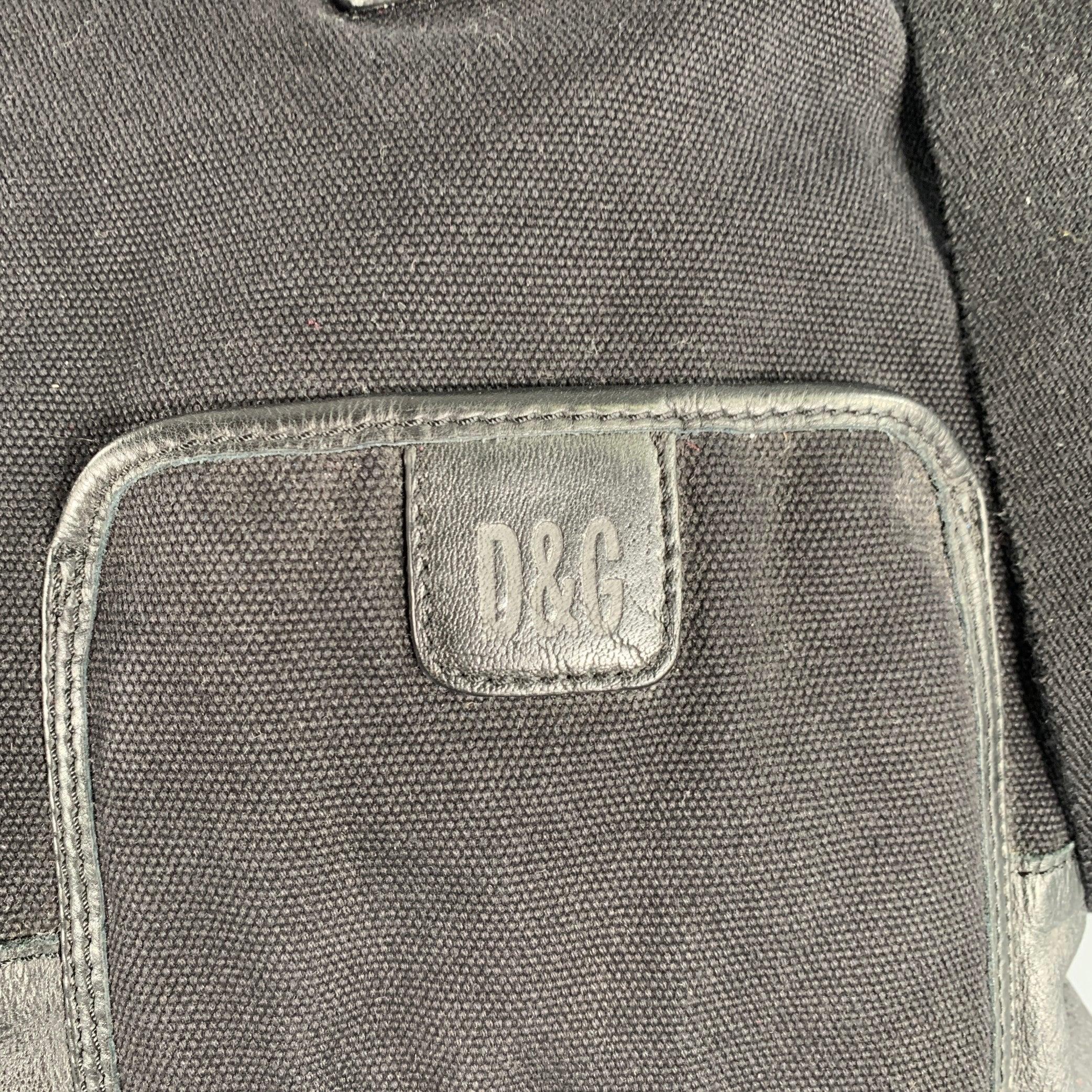 D&G by DOLCE & GABBANA handbag
in a black canvas and leather featuring a tote style with rolled leather top handles, adjustable crossbody strap, and silver tone metal zip closure.Very Good Pre-Owned Condition. 

Measurements: 
  Length: 14.5 inches