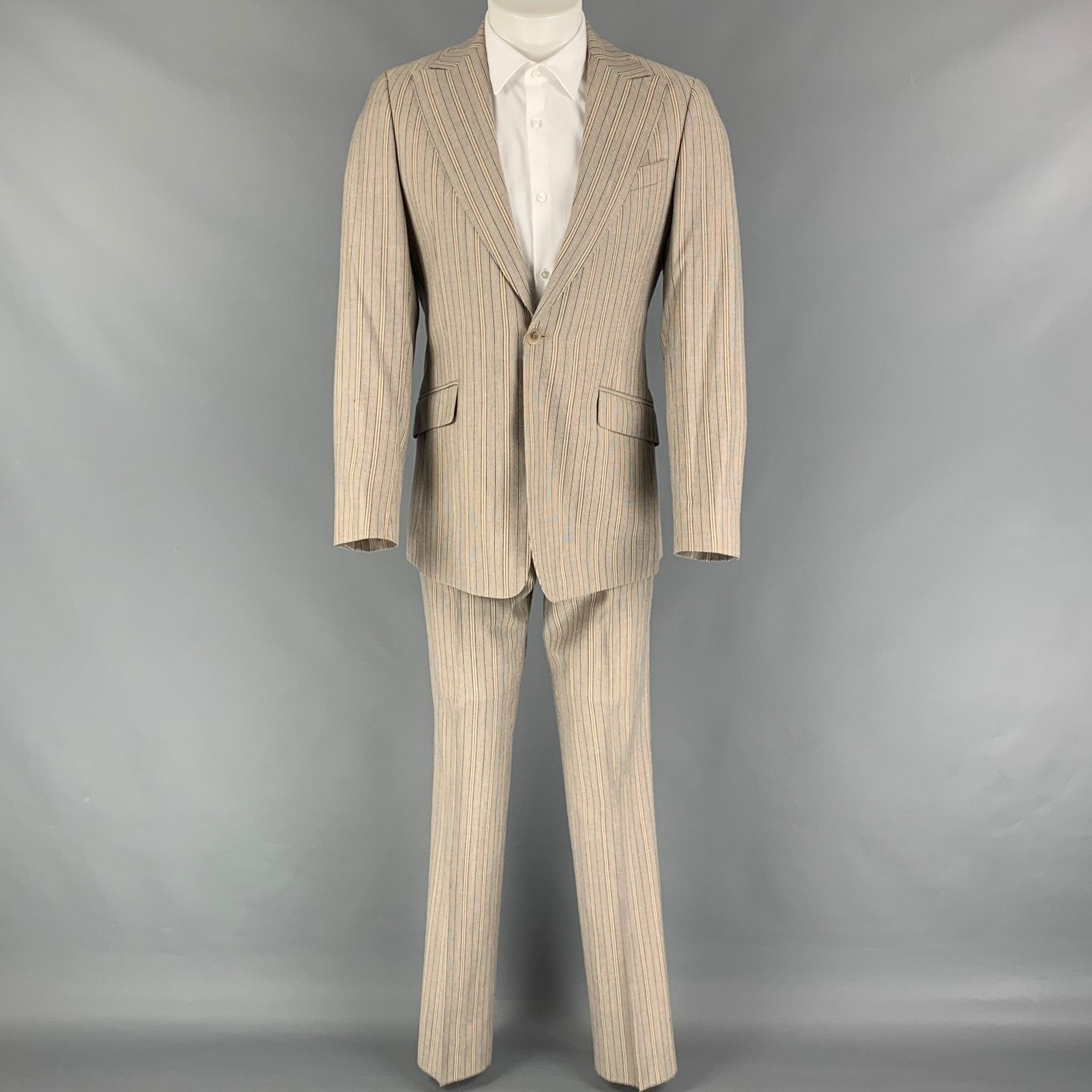 D&G by DOLCE & GABBANA
suit comes in a khaki & navy stripe polyester blend with a full liner and includes a single breasted, single button sport coat with a peak lapel and matching flat front trousers. Made in Italy. Very Good Pre-Owned Condition.