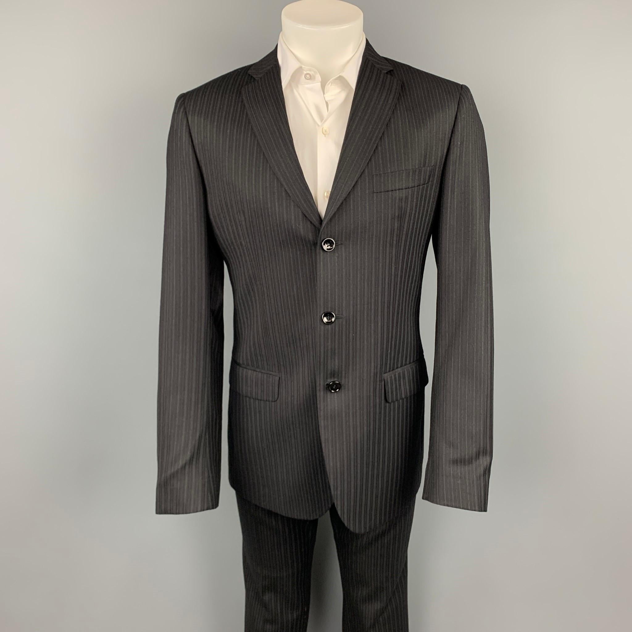 D&G by DOLCE & GABBANA suit comes in a black stripe wool blend with a full liner and includes a single breasted, three button sport coat with a notch lapel and matching flat front trousers. Made in Italy.

Very Good Pre-Owned Condition.
Marked: IT