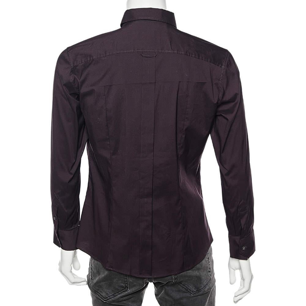 Cette chemise Brad de D.G. est très élégante et très confortable pour une utilisation formelle. Il est cousu dans un tissu de coton bordeaux foncé et présente un devant boutonné, des manches longues et un col. En portant cette chemise avec votre