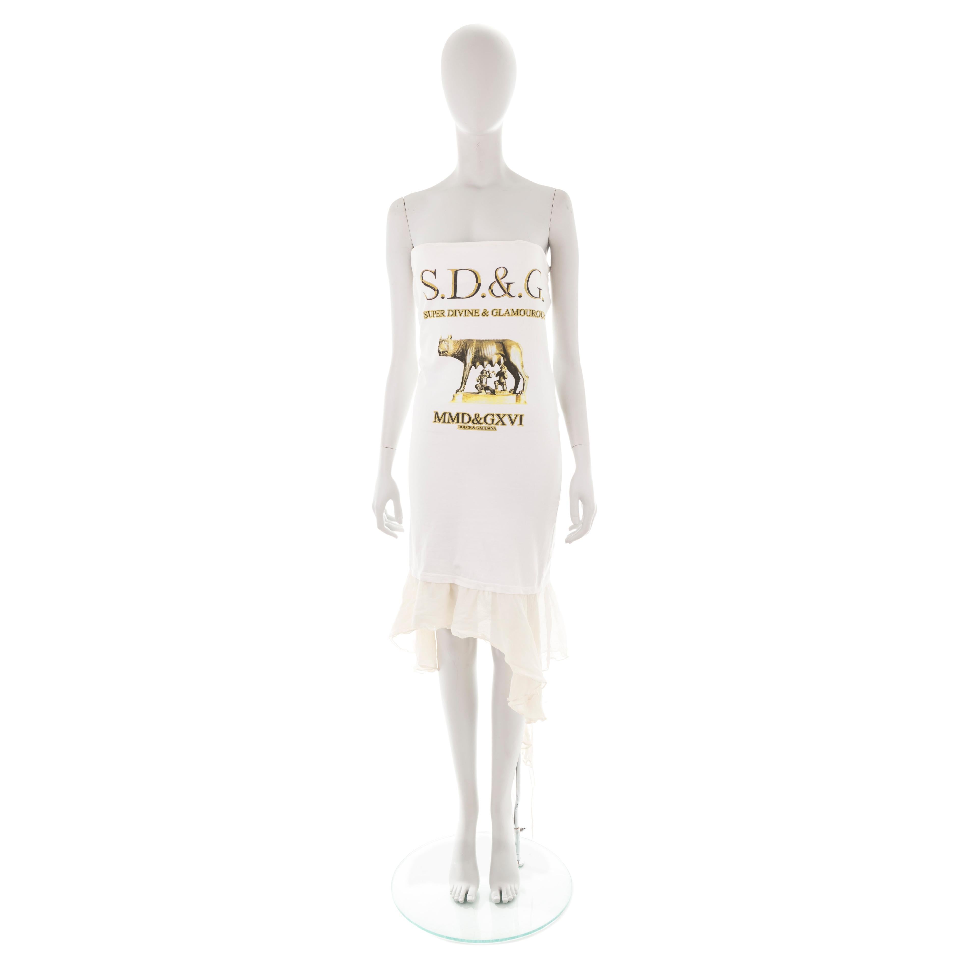 - D&G by Dolce & Gabbana 
- Sold by Gold Palms Vintage
- Spring/Summer 2003
- White cotton midi tube dress
“Capitoline wolf” inspired print with logo slogan
- Silk chiffon jellyfish hem
- Size 44 
- Small stain on the back (not noticeable when