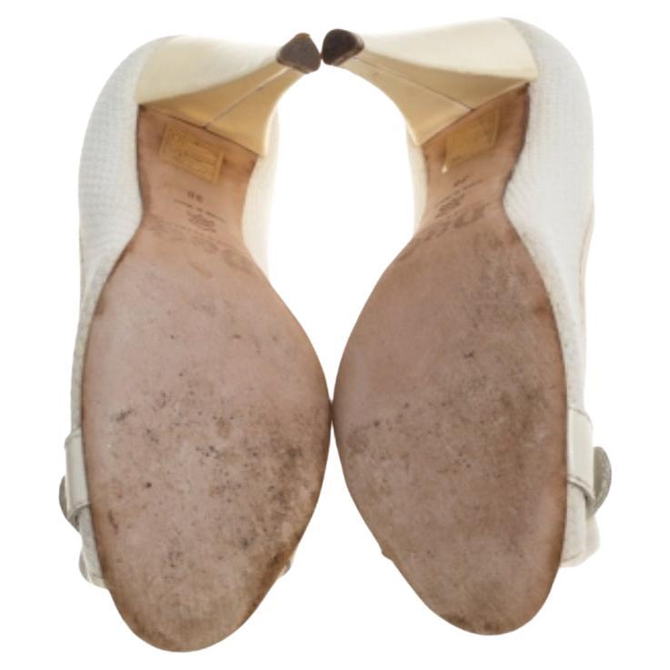 Flaunt this fabulous pair of D & G pumps with grace to elevate your style. The plush design of these classic white-hued pumps will lend an elegant touch to your look. They have been crafted from woven fabric and patent leather. They have been styled