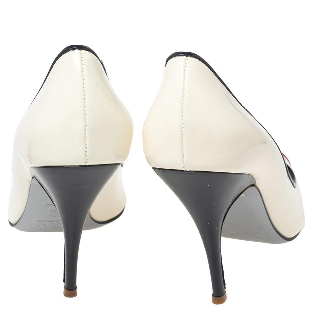 These chic and classic D&G peep-toe pumps can be worn to work as well as for a casual outing. The pair is crafted with patent leather in a pretty white hue. They come with bows on the vamps, contrasting trims, and 11 cm high heels.

