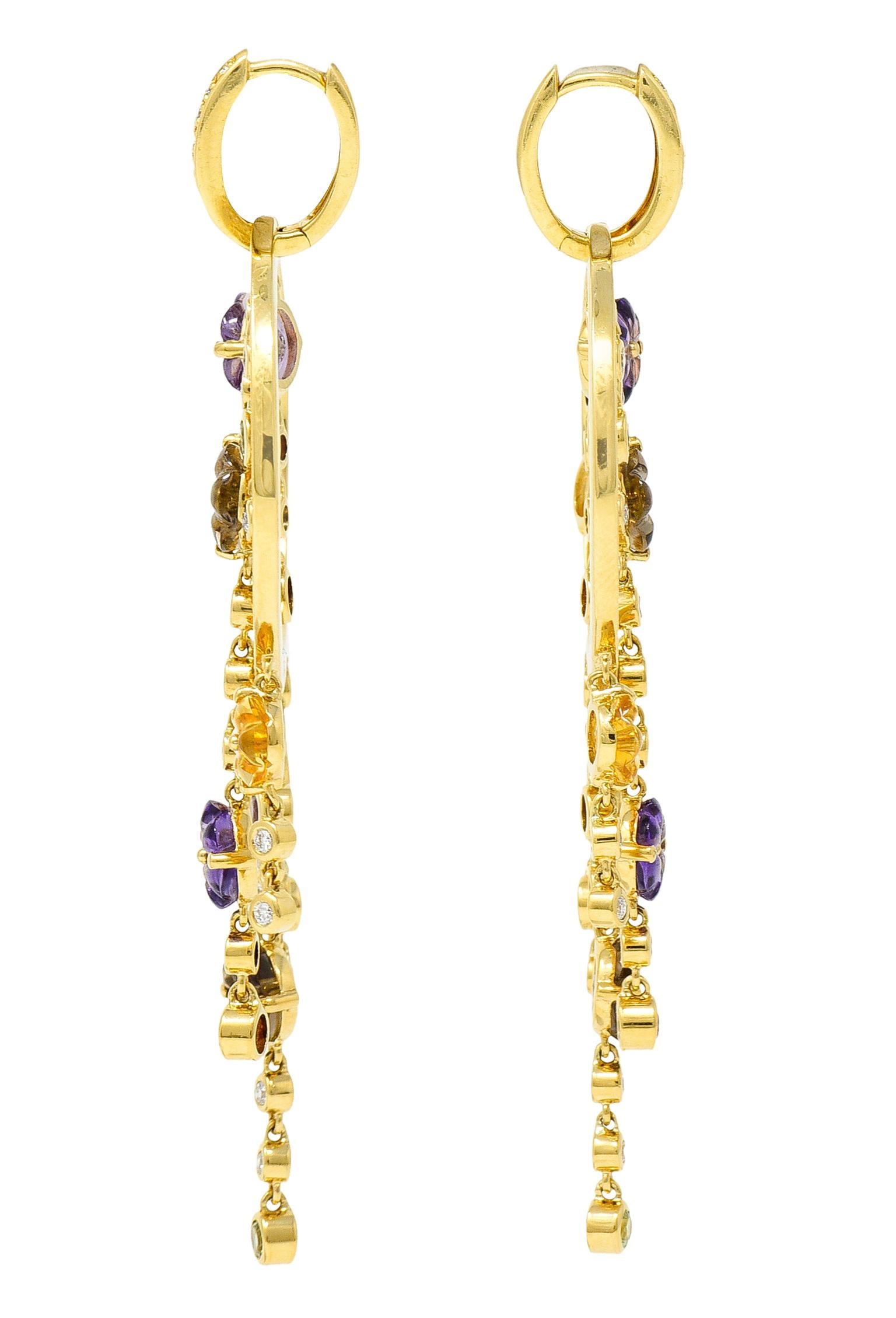 Substantial earrings are designed with a diamond huggie hoop surmount

Suspending a large circular drop decorated with articulated gemstone fringe

Featuring carved flowers and round cut amethysts, peridot, smokey quartz, citrine, and