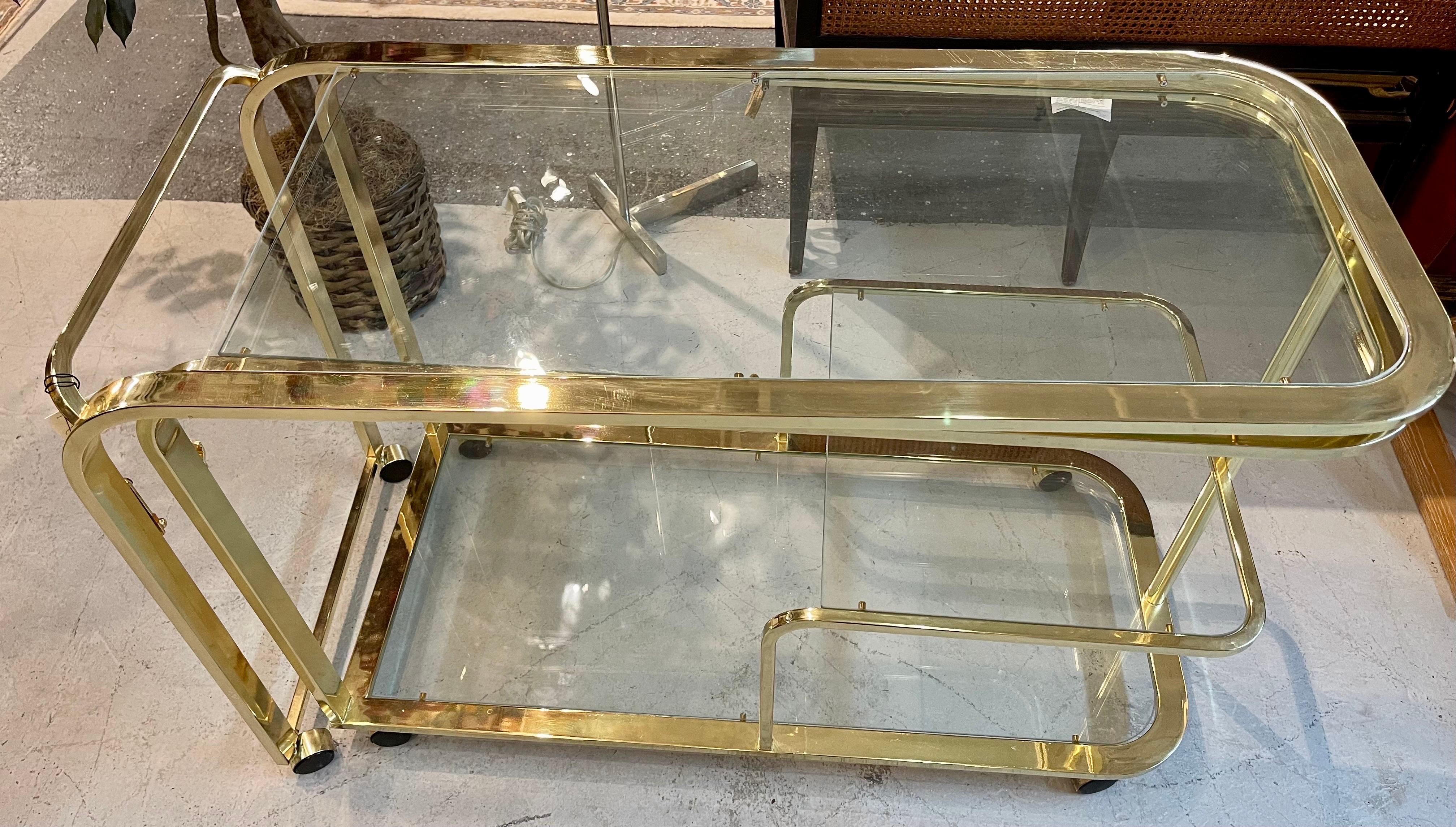 Gorgeous Design Institute of America (DIA) expandable chrome, brass and glass rolling bar cart. Features ease of movement with caster wheels and new glass.
Classic mid century lines. Brass/chrome has some wear which give this piece even more