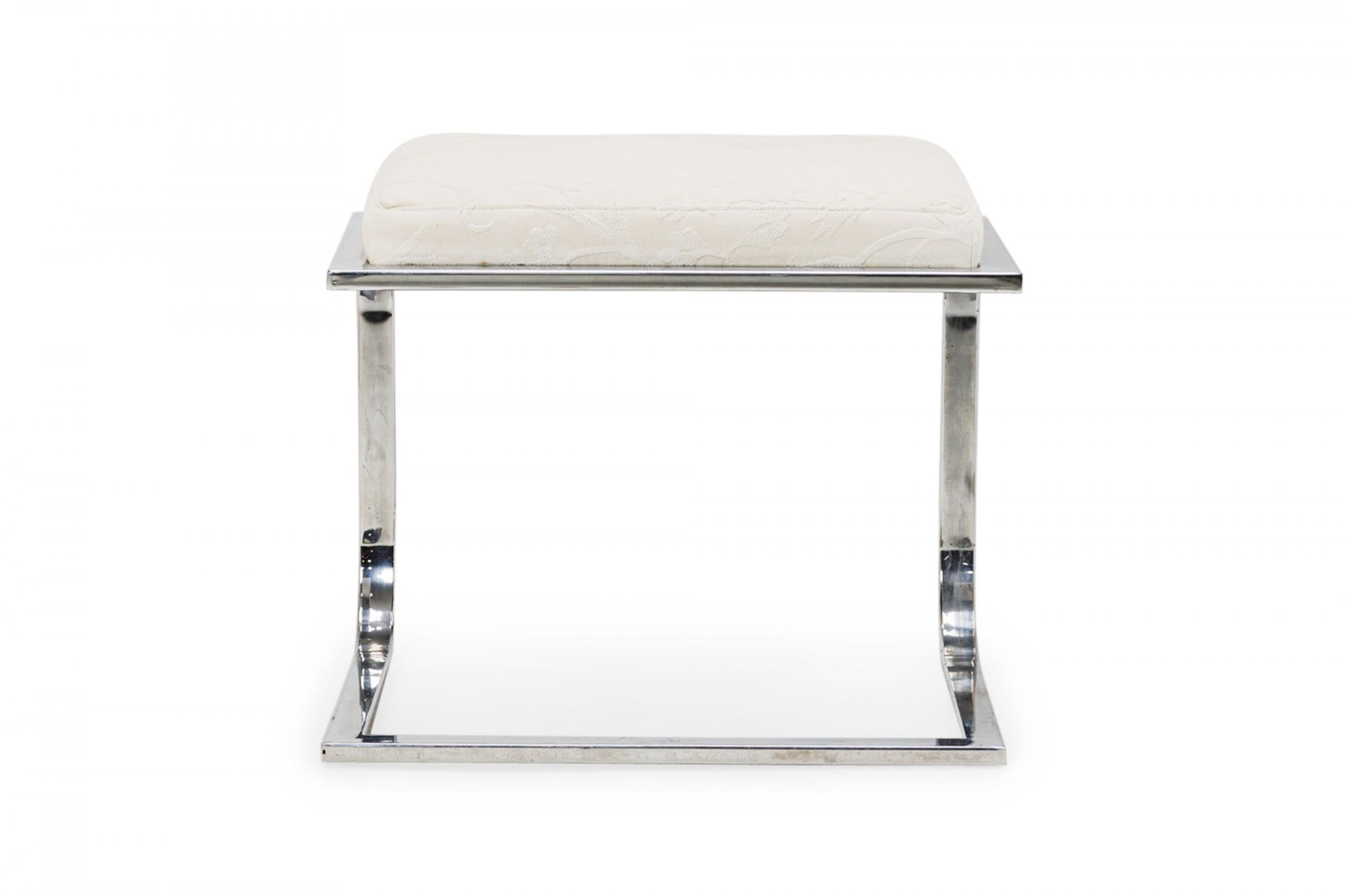 American Mid-Century cantilever design footstool with a curved square chrome tube base supporting a rectangular beige upholstered top with a faint floral pattern. (DIA DESIGN INSTITUTE OF AMERICA)
