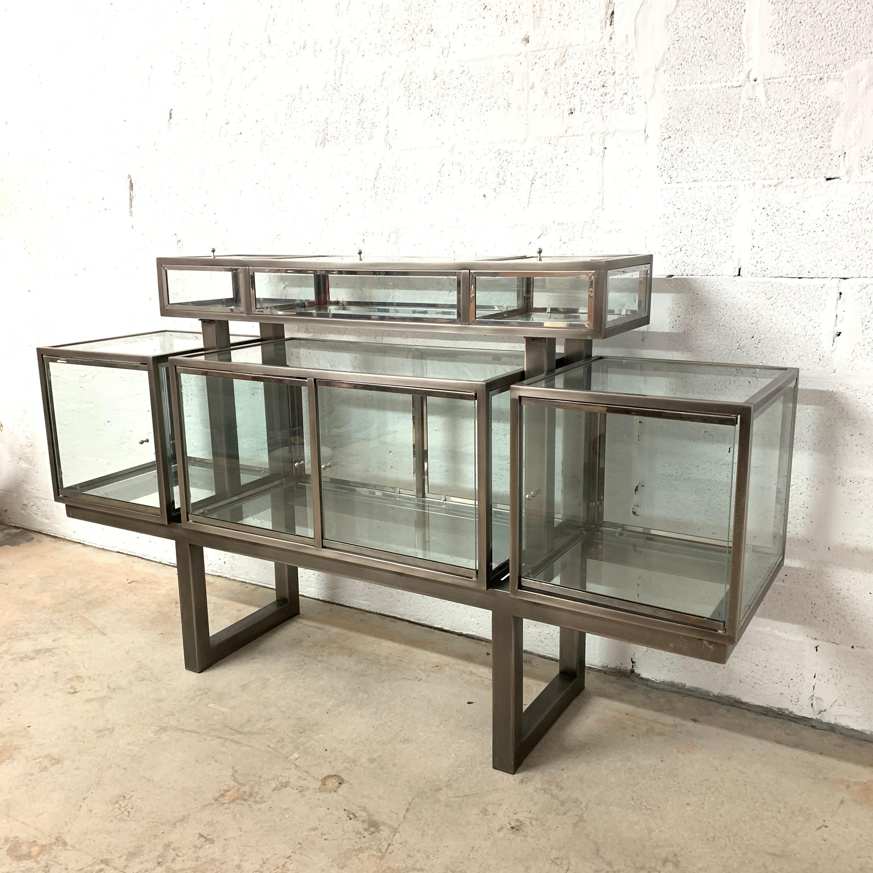 Postmodern display cabinet or vitrine. Composed of 6 compartments, 3 lower and 3 raised, each with glass doors for access. Rendered in brushed steel, polished chrome and glass by DIA, Design Institute of America, 1980s.

Dimensions:
18
